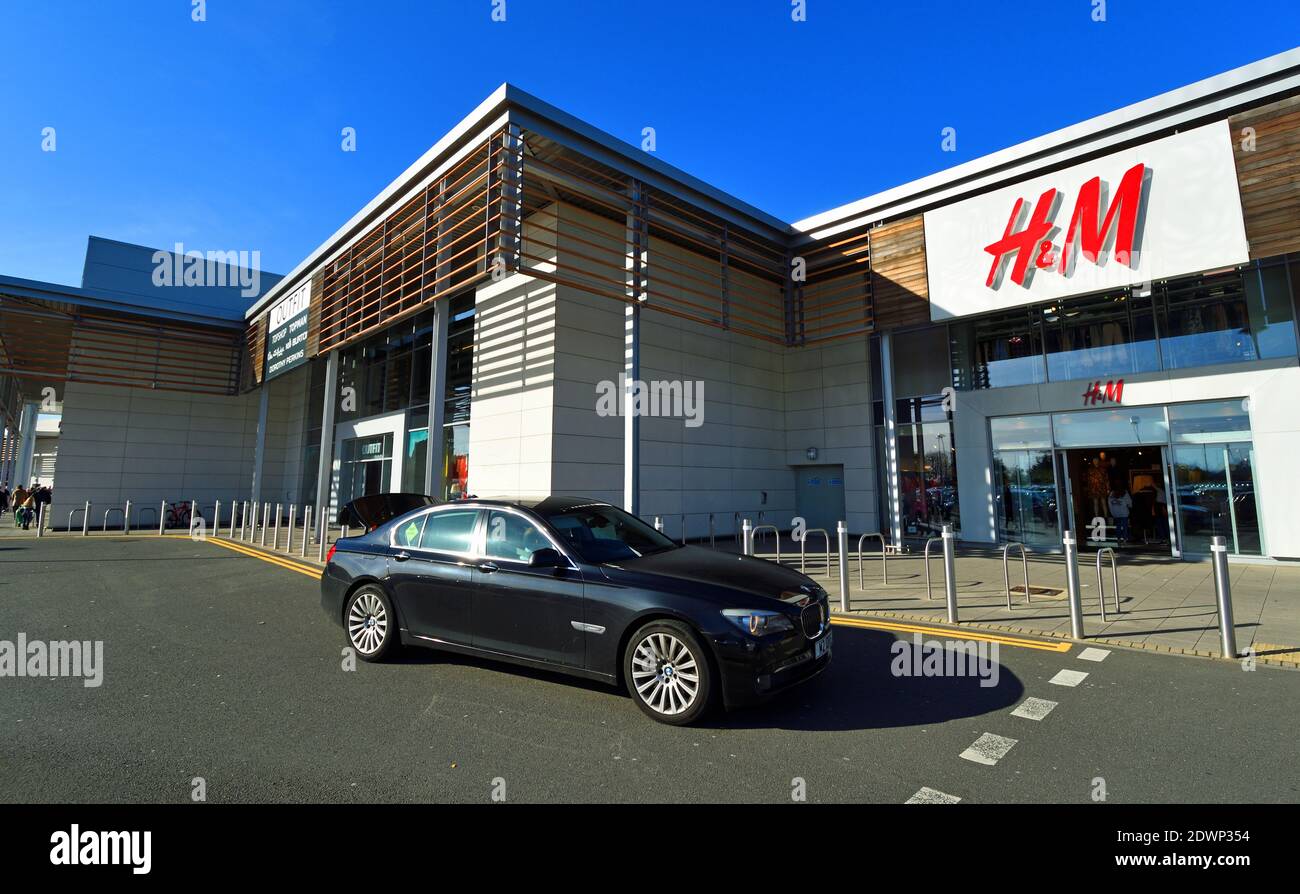Auto BMW nel parcheggio al dettaglio all'esterno del negozio H & M. Foto Stock