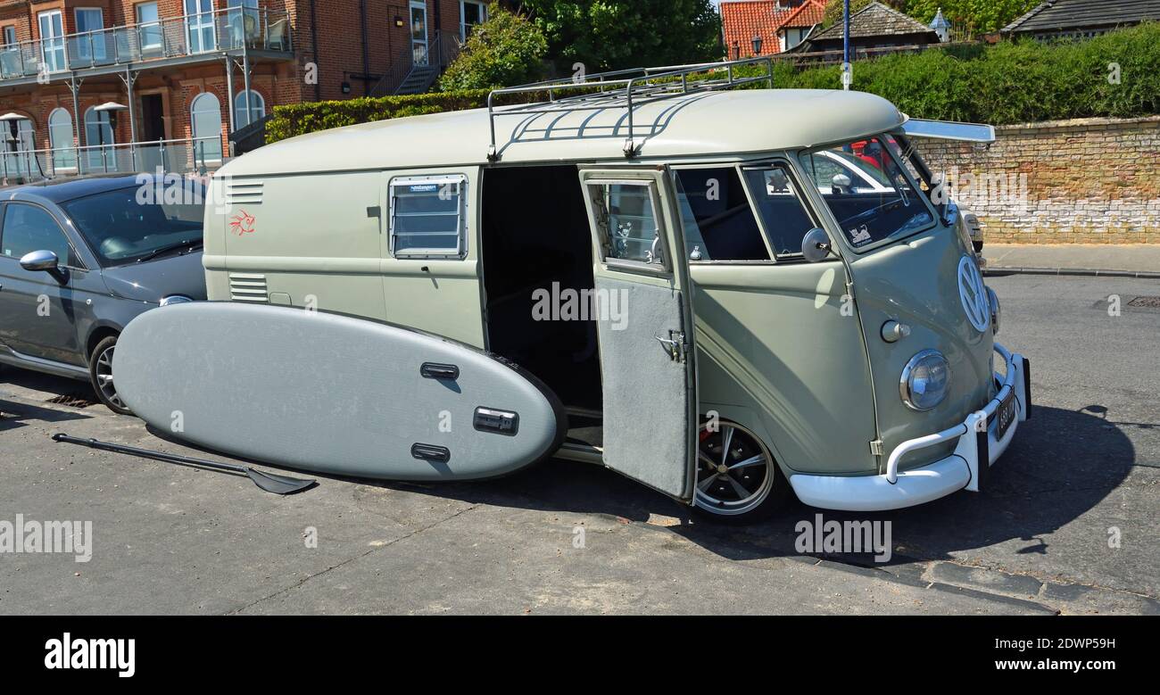 Pulmino Classic VW Camper con paddle board parcheggiato con porta laterale aperta. Foto Stock