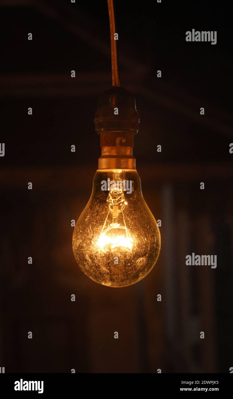 Close-up di luce che si accende la lampadina nel buio Foto stock - Alamy