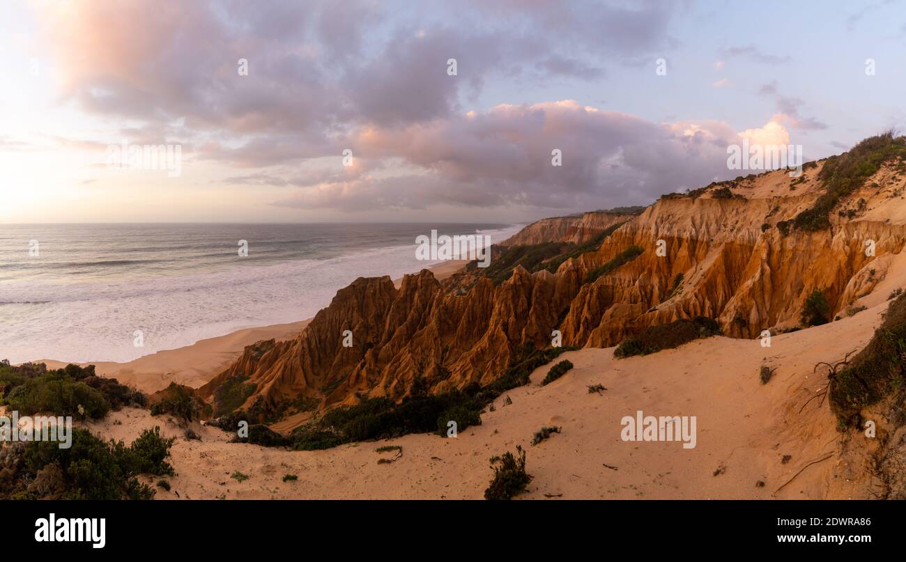Molte bizzarre dune di sabbia erose sull'Oceano Atlantico con onde che si infrangono al tramonto Foto Stock