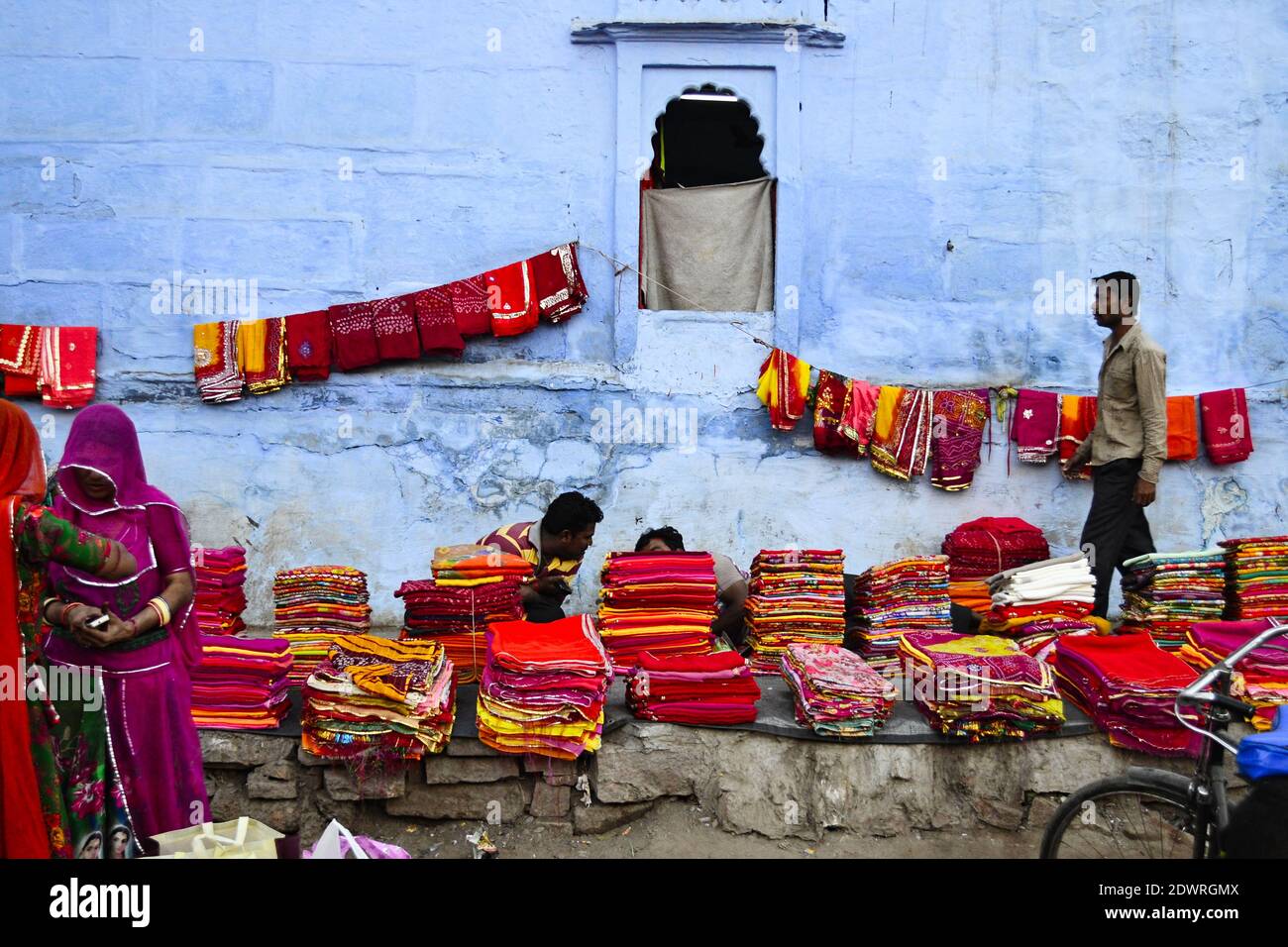 Jodhpur, Rajasthan, India - Dicembre, 2016: La gente che vende i saree, i tessuti colorati ed altri tessuti del tessuto ed altri tessuti indiani sul contrassegno della strada Foto Stock