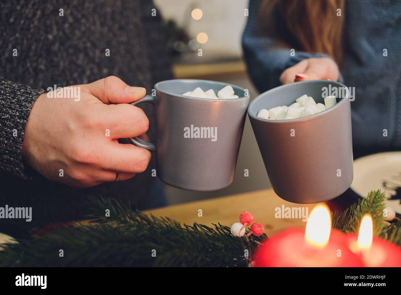 Due bicchieri di cacao fatti in casa con marshmallows. Bevanda calda invernale su sfondo di legno decorata con bastoni di cinamon e rami di abete Foto Stock