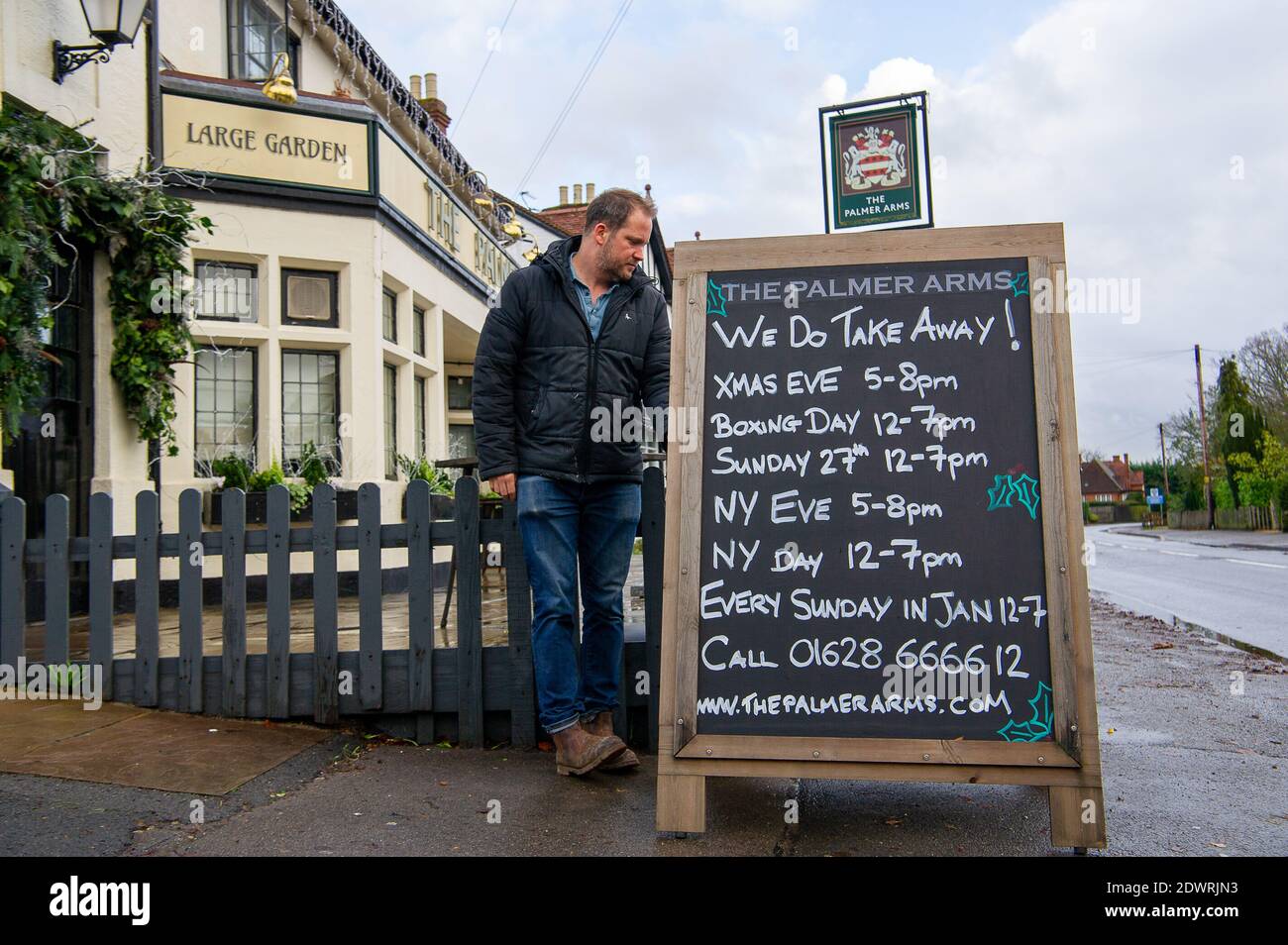 Dorney, Buckinghamshire, Regno Unito. 23 dicembre 2020. Chrys Fisher pub padrone del popolare pub del villaggio di Dorney il Palmer Arms, stava mettendo un segno oggi con i loro orari di apertura per i takeaways durante il Natale e il Capodanno. Anche se è stato un momento difficile per i pub e ristoranti a causa del Covid-19 Pandemic, molti proprietari di pub stanno mostrando la loro resilienza e sostenere i comuni locali in tutto il Covid-19 Pandemic. Credit: Maureen McLean/Alamy Live News Foto Stock