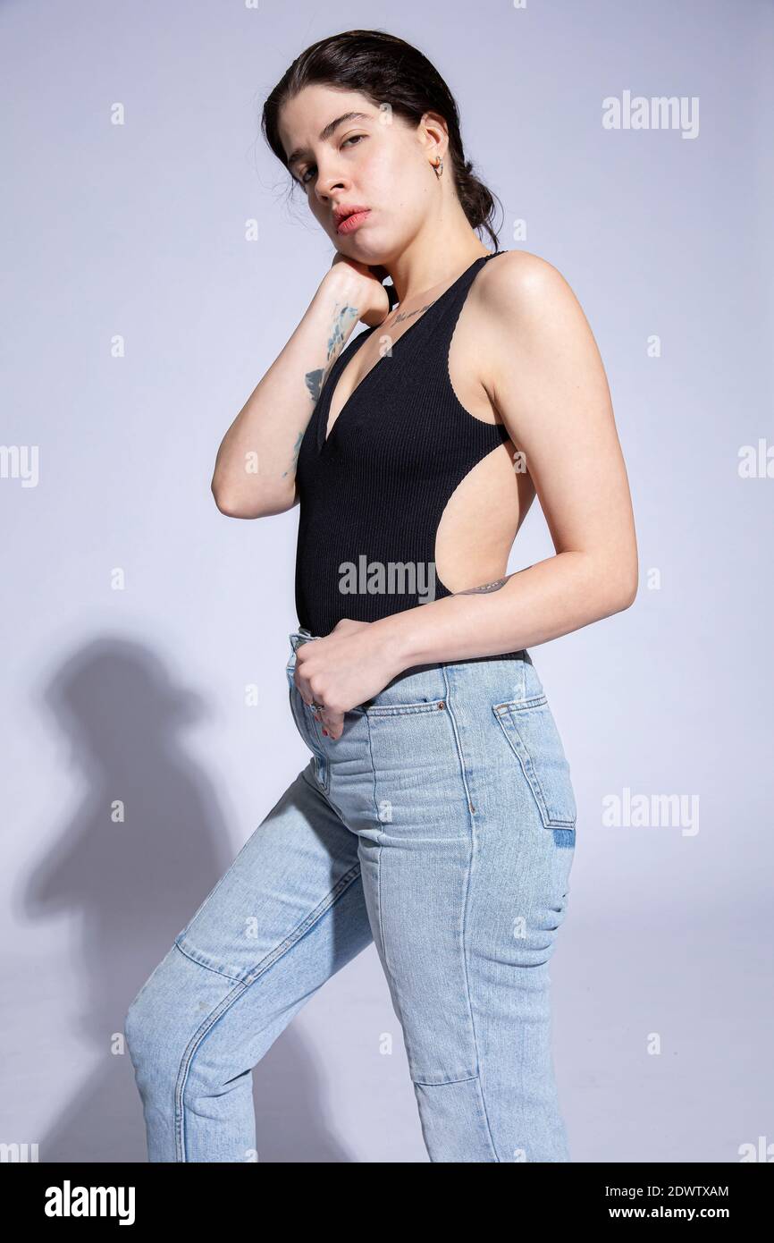 Giovane donna in cima nera isolata su viola Foto Stock