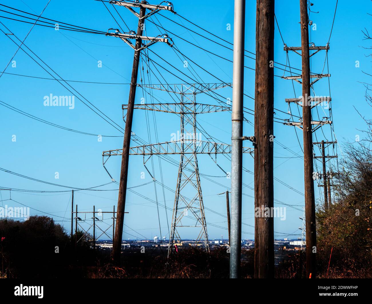 Futuro quando l'elettricità corre la Terra---l'energia viene dalle linee elettriche alle città lungo un corridoio di utilità in Dallas Texas trasmissione elettrica e torri di microonde. Trasporta l'elettricità generata dal carbone, dal gas naturale o dalle centrali nucleari alle case e alle aziende nel Texas del nord. Alimentato da una serie di parchi eolici solari e distanti, l'instradamento dell'elettricità attraverso il paese grazie a una rete di linee elettriche su un'infrastruttura di linee Foto Stock
