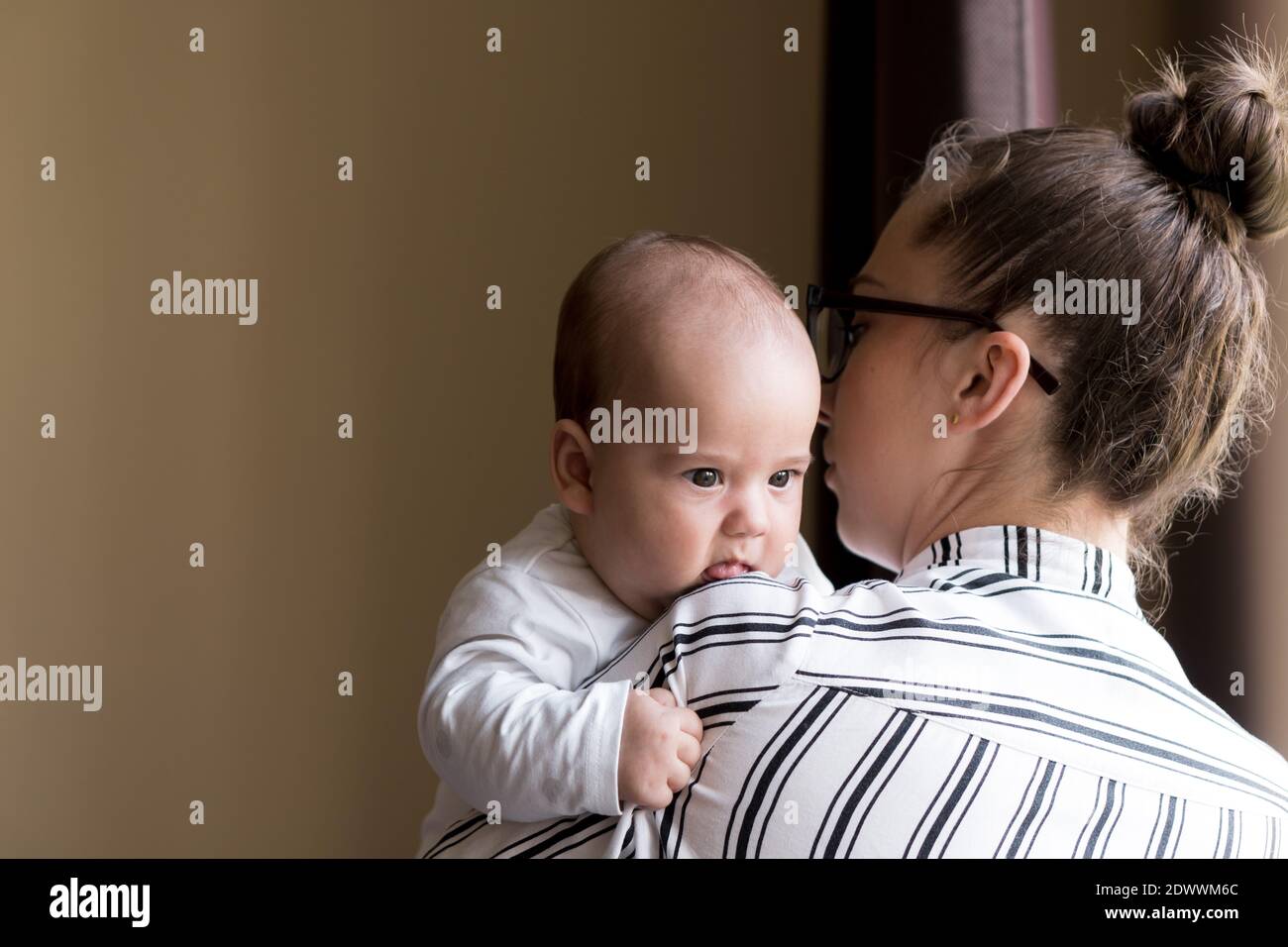 Infanzia, maternità, concetti di famiglia - successo sorridente ricca donna d'affari Signora madre tenendo bambino neonato bambino neonato nelle sue mani si alza e Foto Stock