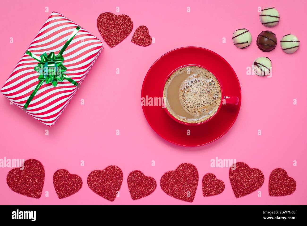 Romantico San Valentino con cuori rossi e tazza di caffè e cioccolato su sfondo di carta rosa, modello. Simbolo di San Valentino, vacanza romantica, vino Foto Stock
