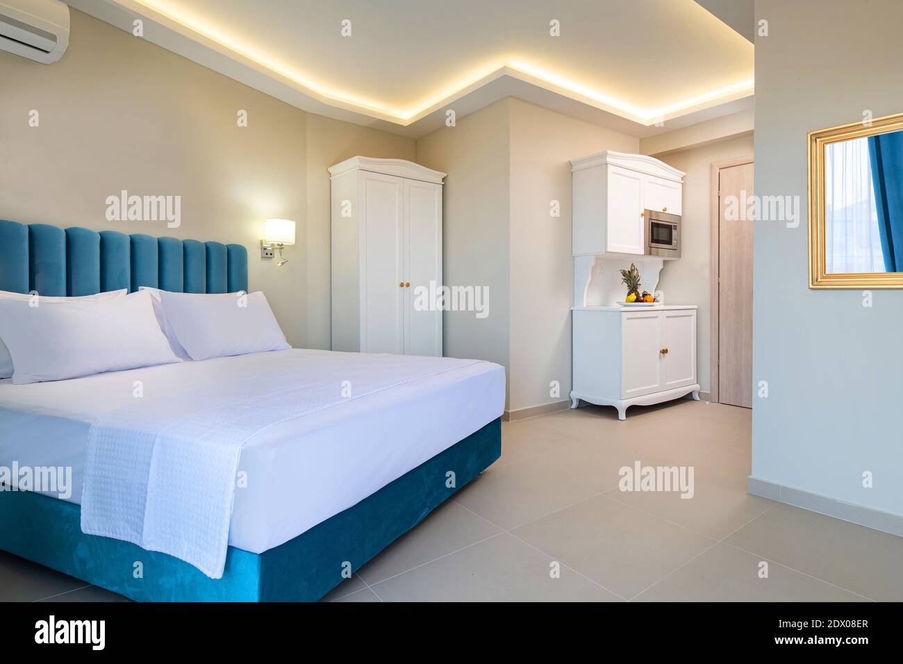 Interni in stile classico con camera da letto bianca e blu con cucina armadio a muro in appartamento doppia suite Foto Stock