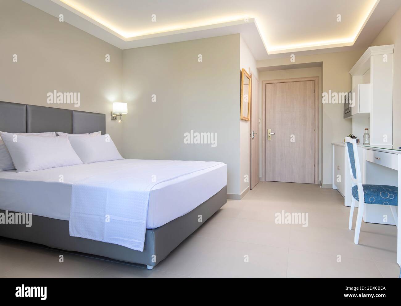 Interni bianchi in stile classico della camera da letto dell'hotel, bagno, cucina in uno spazio singolo di un piccolo appartamento monolocale moderno Foto Stock