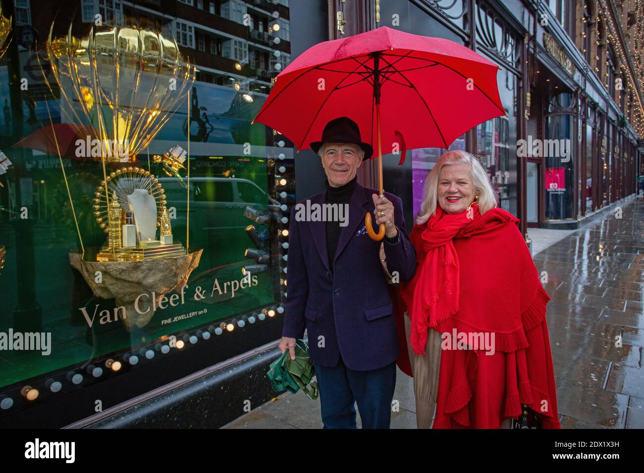 Gran Bretagna / Inghilterra / Londra /UNA coppia in posa davanti alla vetrina dello shopping al Harrods Knightsbridge a Londra il 23 dicembre 2020. Foto Stock