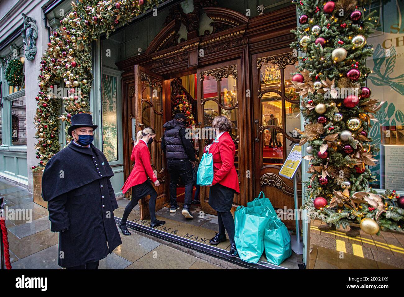 Inghilterra /Londra/ Piccadilly/ Doorman indossa una maschera facciale a causa della pandemia COVID-19, a Fortnum & Mason a Londra il 23 dicembre 2020. Foto Stock