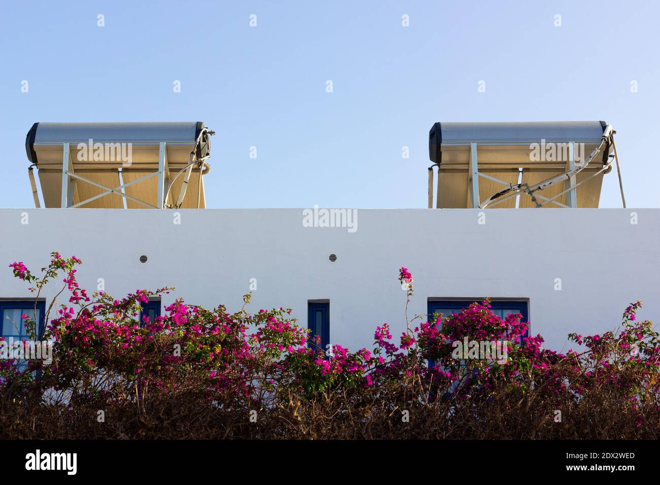 Pannelli solari sul tetto del complesso di appartamenti bianchi. Moduli fotovoltaici installati sulla parte superiore dell'edificio. Fonte di luce solare del concetto di energia Foto Stock