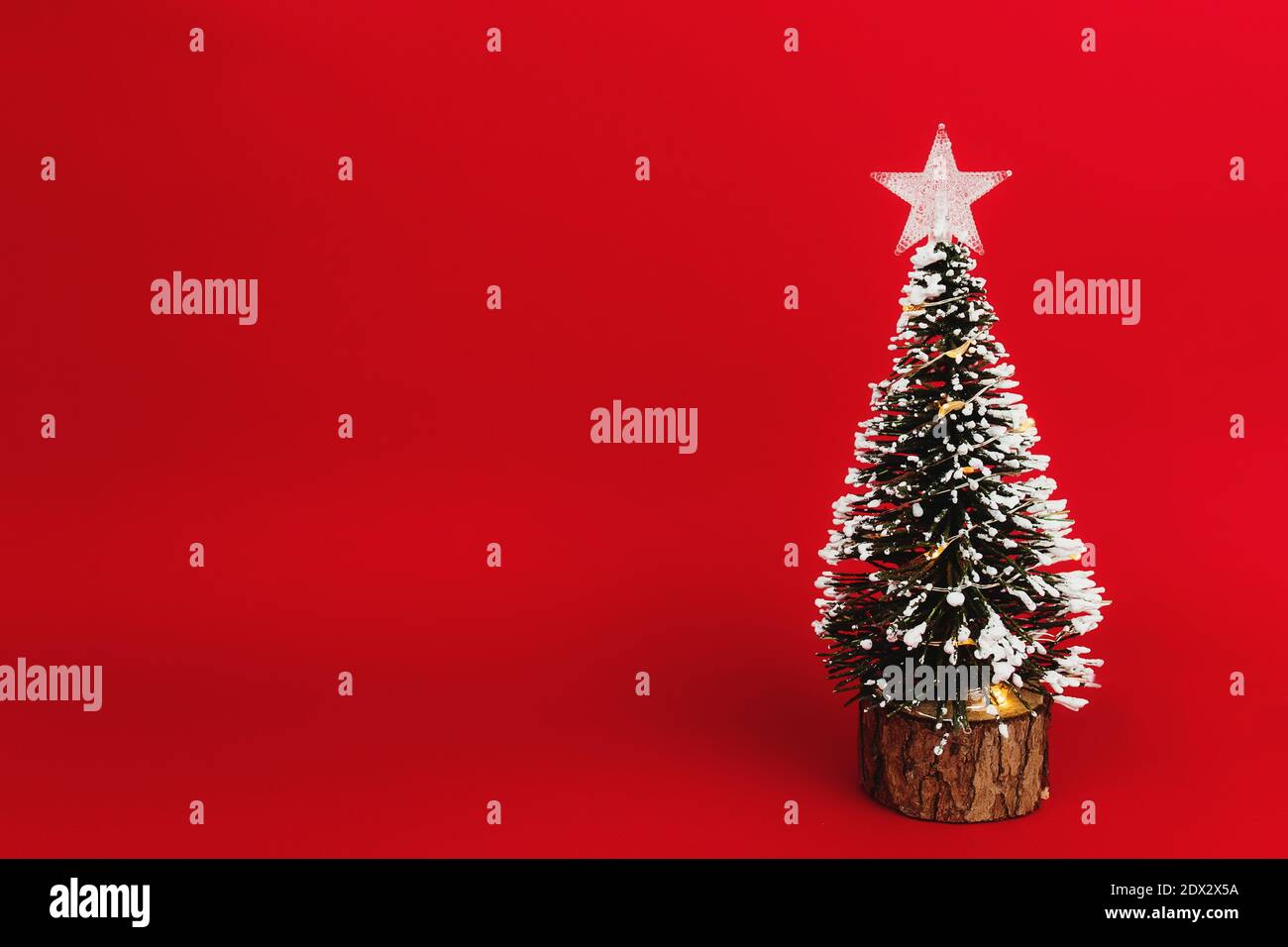 Piccolo albero di natale con stella su sfondo rosso Foto Stock