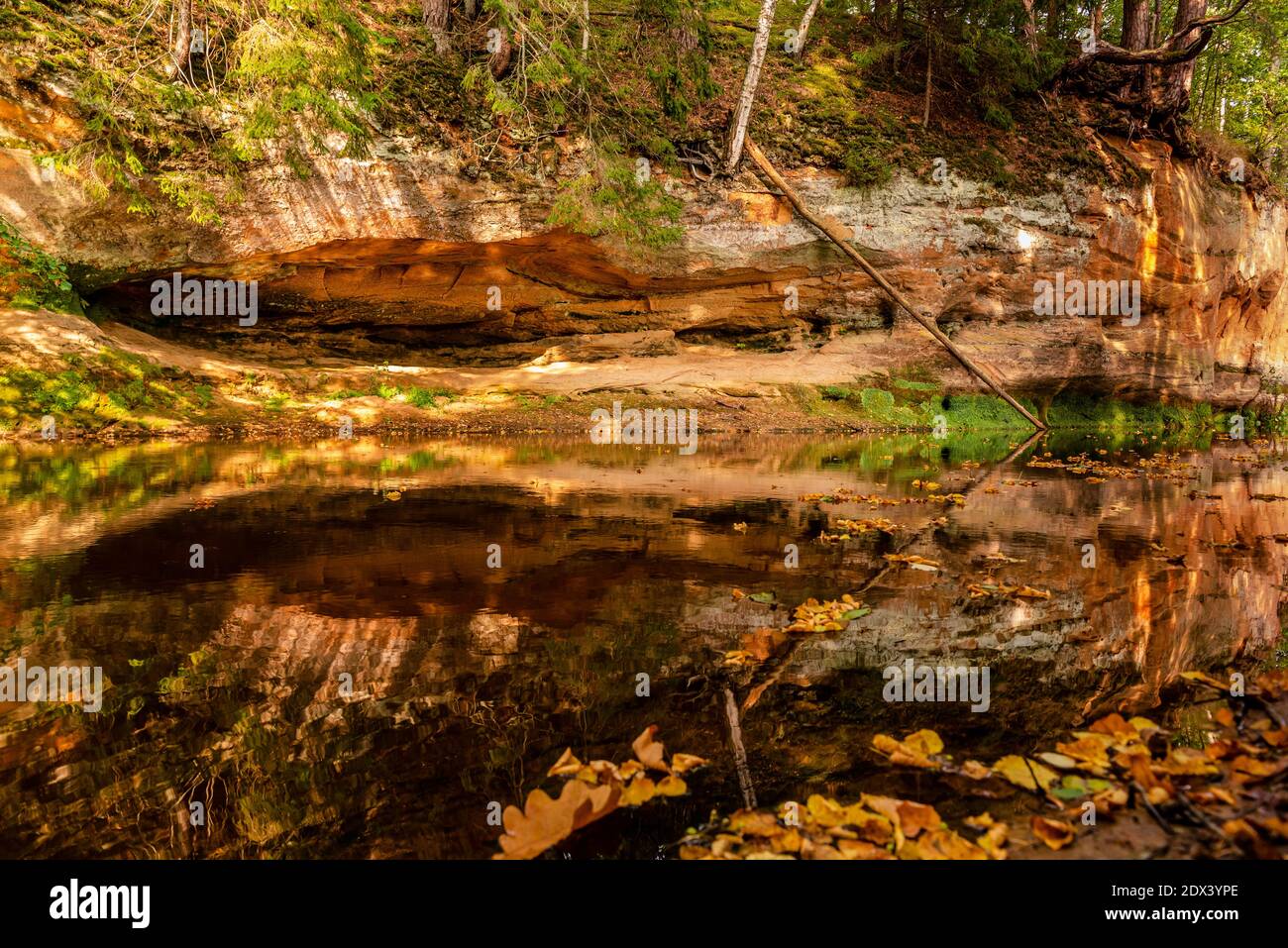 circondato da boschi, la ripida riva del fiume con la calma acqua fluente passato, in cui la bellezza naturale circostante può essere visto come un riferimento Foto Stock