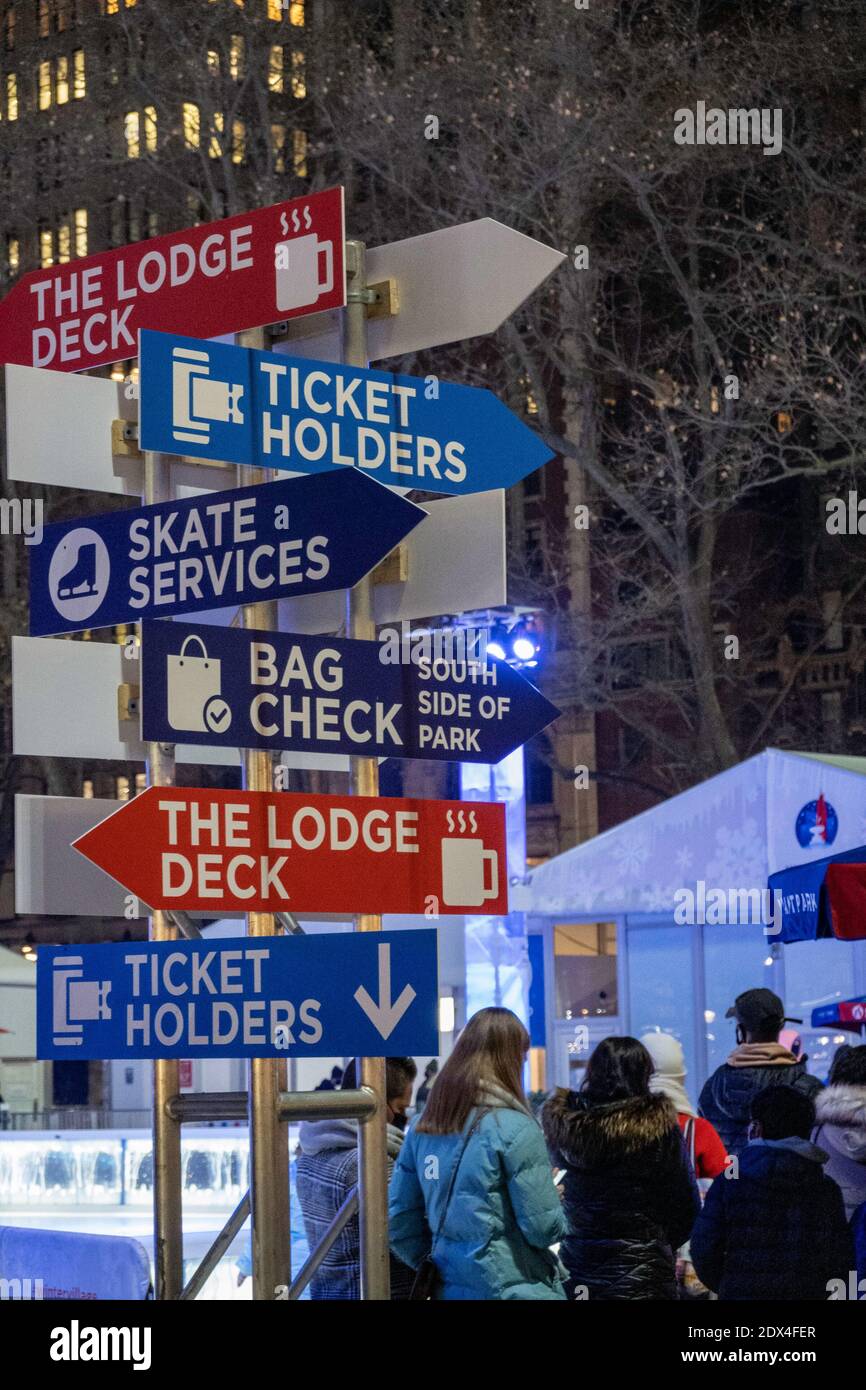 Un cartello nel villaggio invernale di Bryant Park dirige i visitatori verso varie attrazioni, New York City, USA Foto Stock