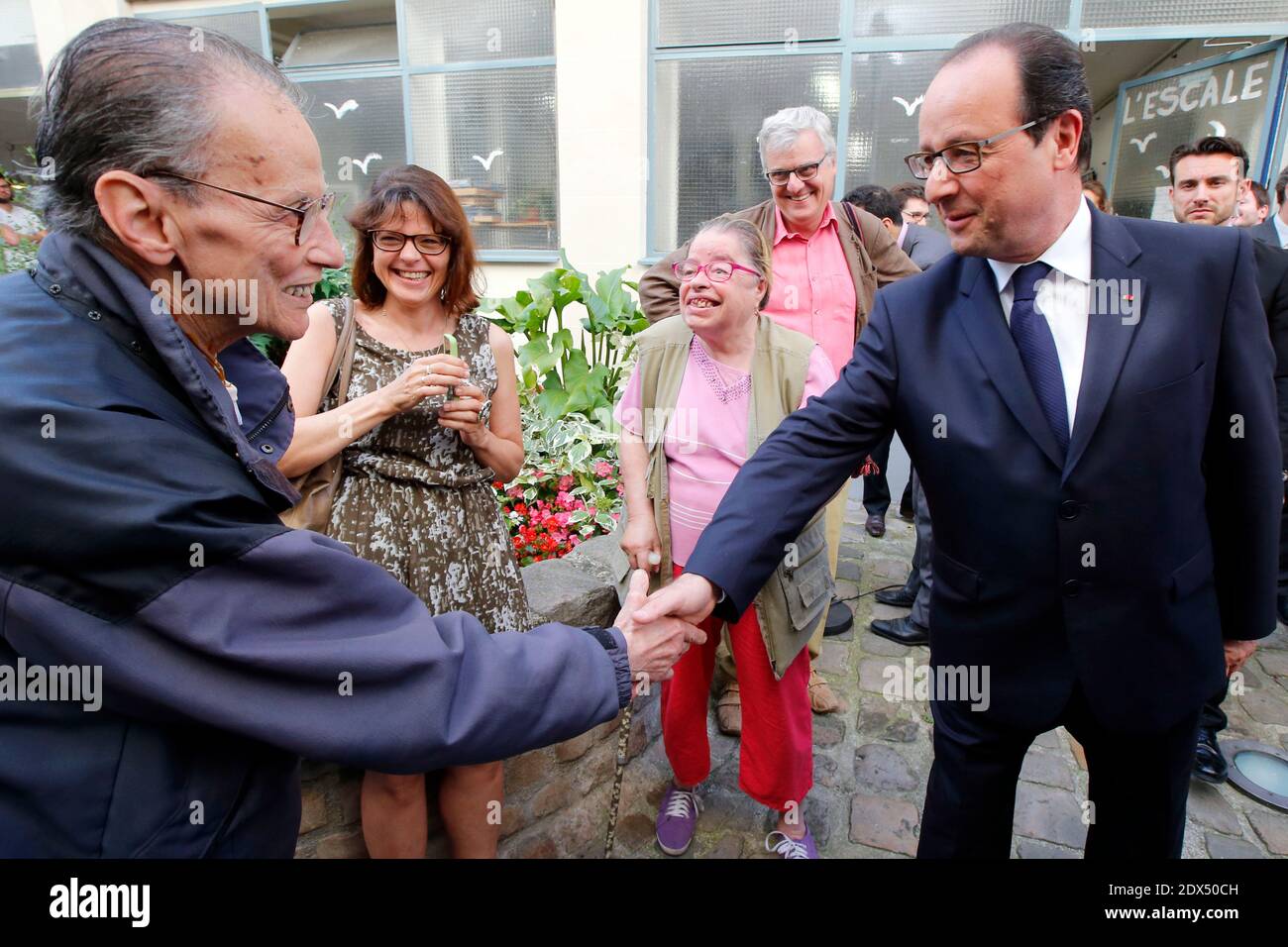 Il presidente francese Francois Hollande scuote le mani a vicini non identificati durante una visita presso un centro di servizio comunitario per aiutare le persone svantaggiate ' Les Petits Freres des Pauvres', a Parigi, Francia, mercoledì 16 luglio 2014. Foto di Francois Mori/ piscina/ ABACAPRESS.COM Foto Stock