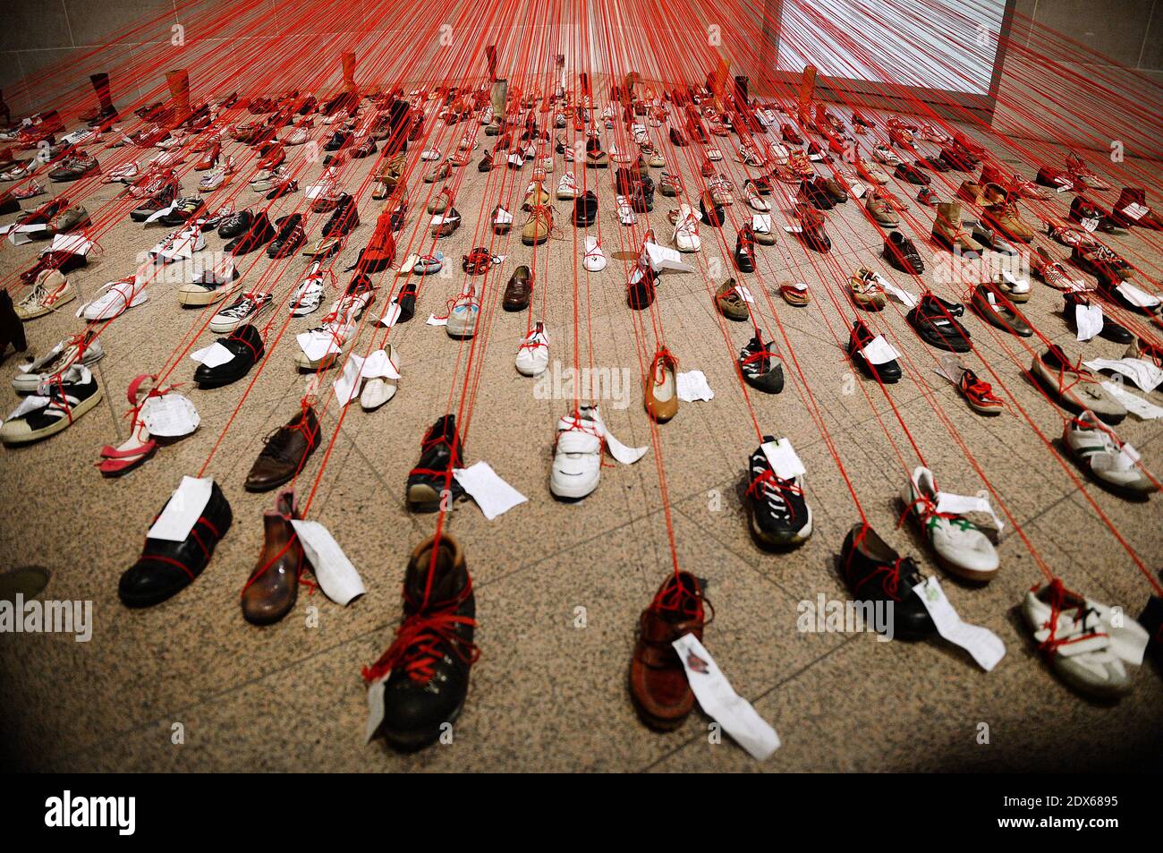 Una mostra d'arte chiamata 'prospettive' dall'artista Chiharu Shiota è in mostra alla Arthur M. Sackler Gallery di Smithsonian, il 22 agosto 2014 a Washington, DC, USA. Perspectives trasforma oltre 400 scarpe attaccate al filato rosso e note manoscritte in un'installazione drammatica ed emotivamente carica. Foto di Olivier Douliery/ABACAPRESS.COM Foto Stock