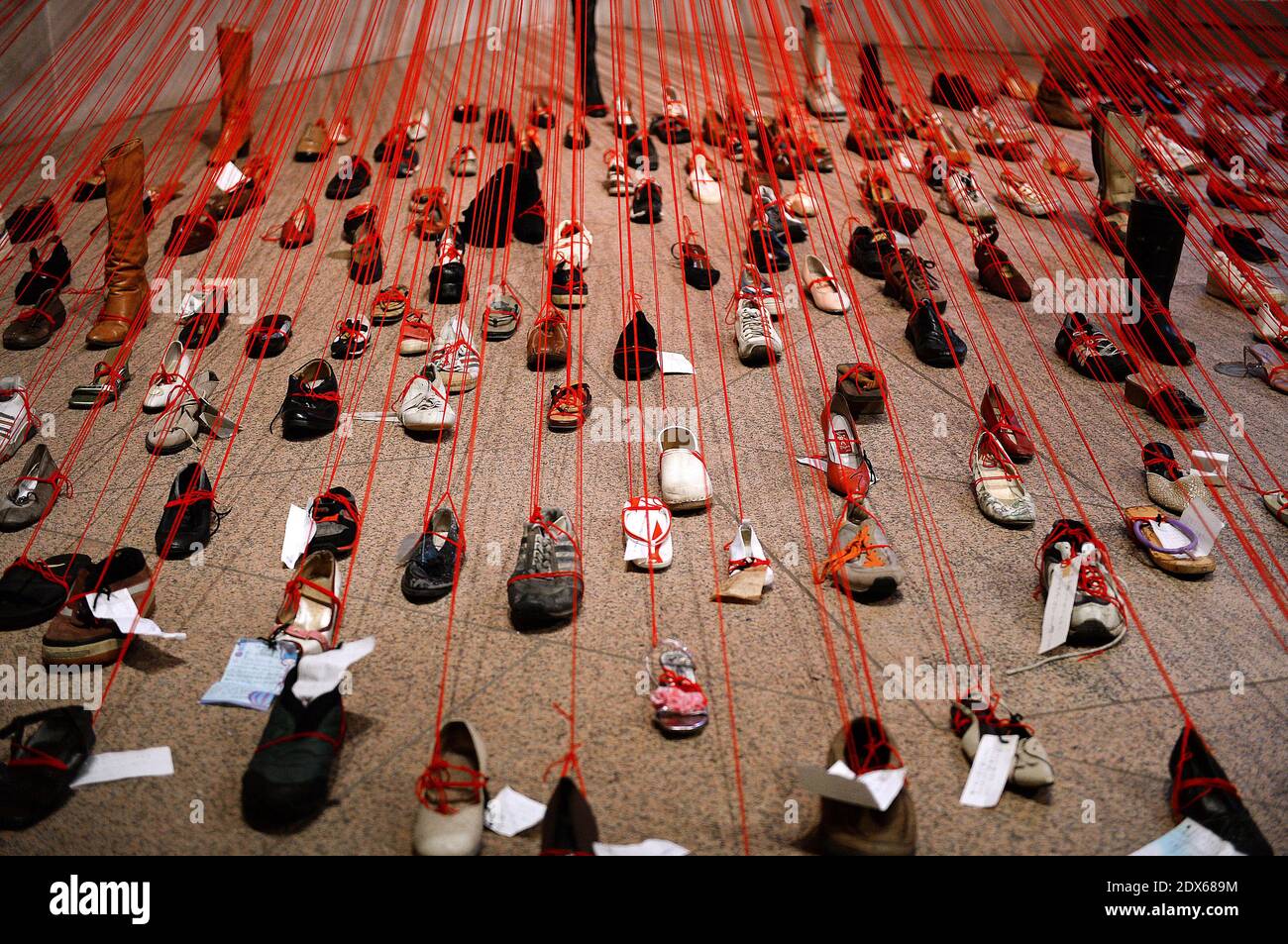 Una mostra d'arte chiamata 'prospettive' dall'artista Chiharu Shiota è in mostra alla Arthur M. Sackler Gallery di Smithsonian, il 22 agosto 2014 a Washington, DC, USA. Perspectives trasforma oltre 400 scarpe attaccate al filato rosso e note manoscritte in un'installazione drammatica ed emotivamente carica. Foto di Olivier Douliery/ABACAPRESS.COM Foto Stock