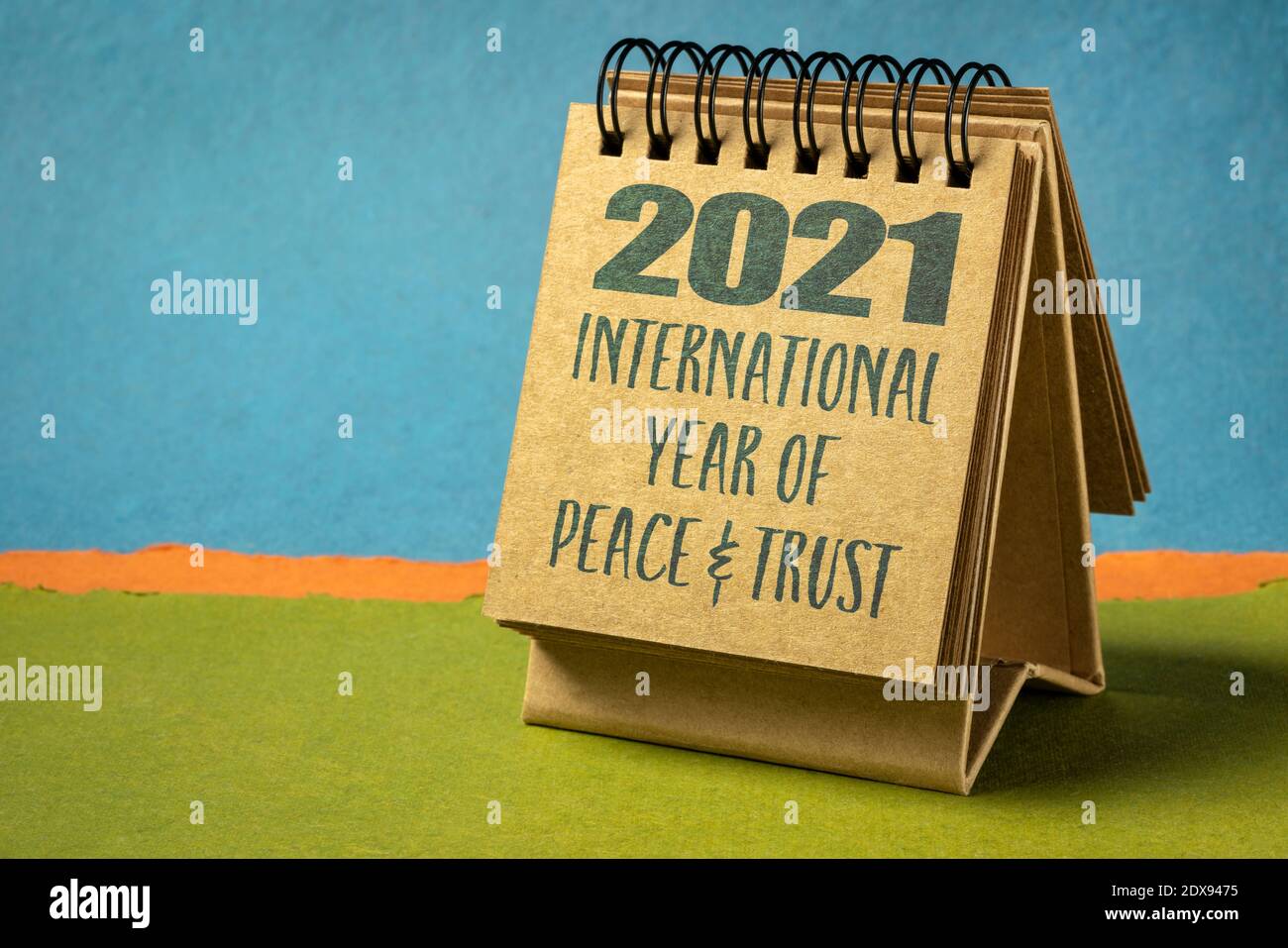 2021 - l'anno Internazionale della Pace e della fiducia dichiarato dalle Nazioni Unite, testo in un calendario a spirale desktop contro il paesaggio astratto della carta Foto Stock