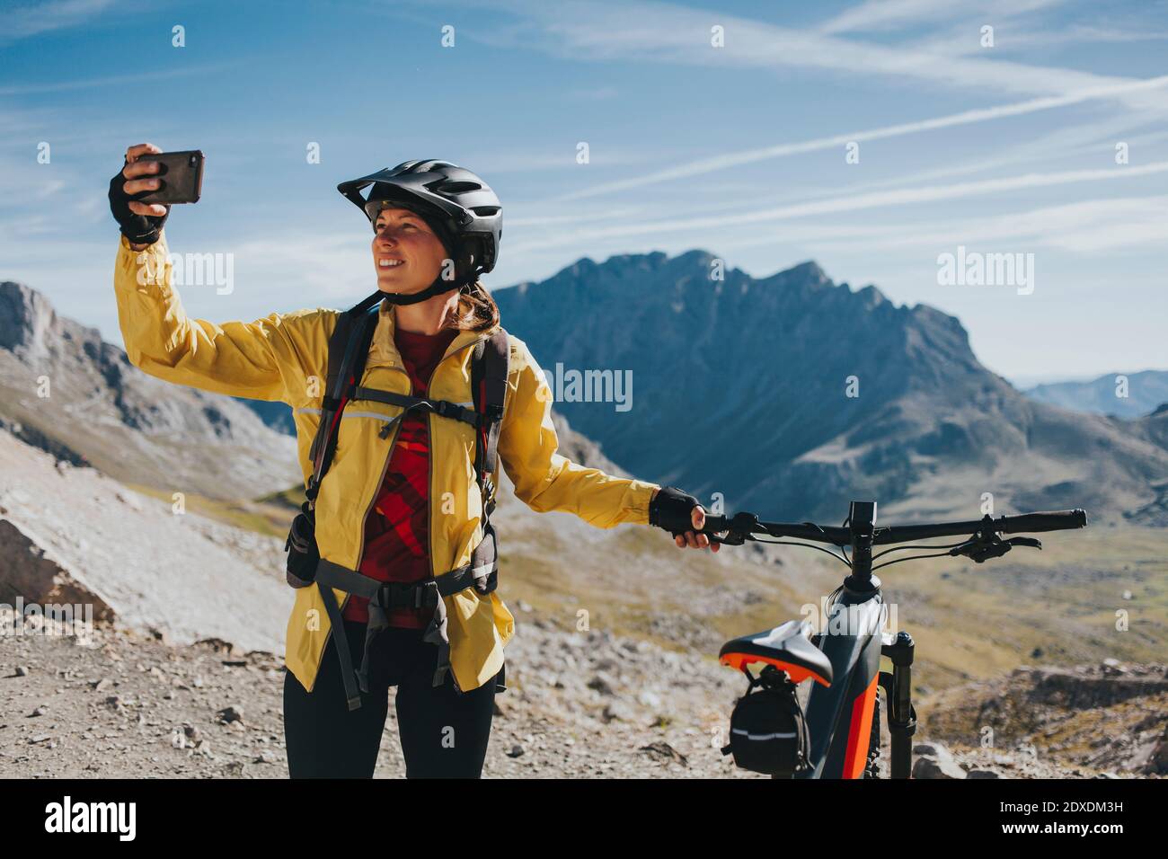 Ciclista femminile con bicicletta che prende selfie al Parco Nazionale di Picos de Europa, Cantabria, Spagna Foto Stock