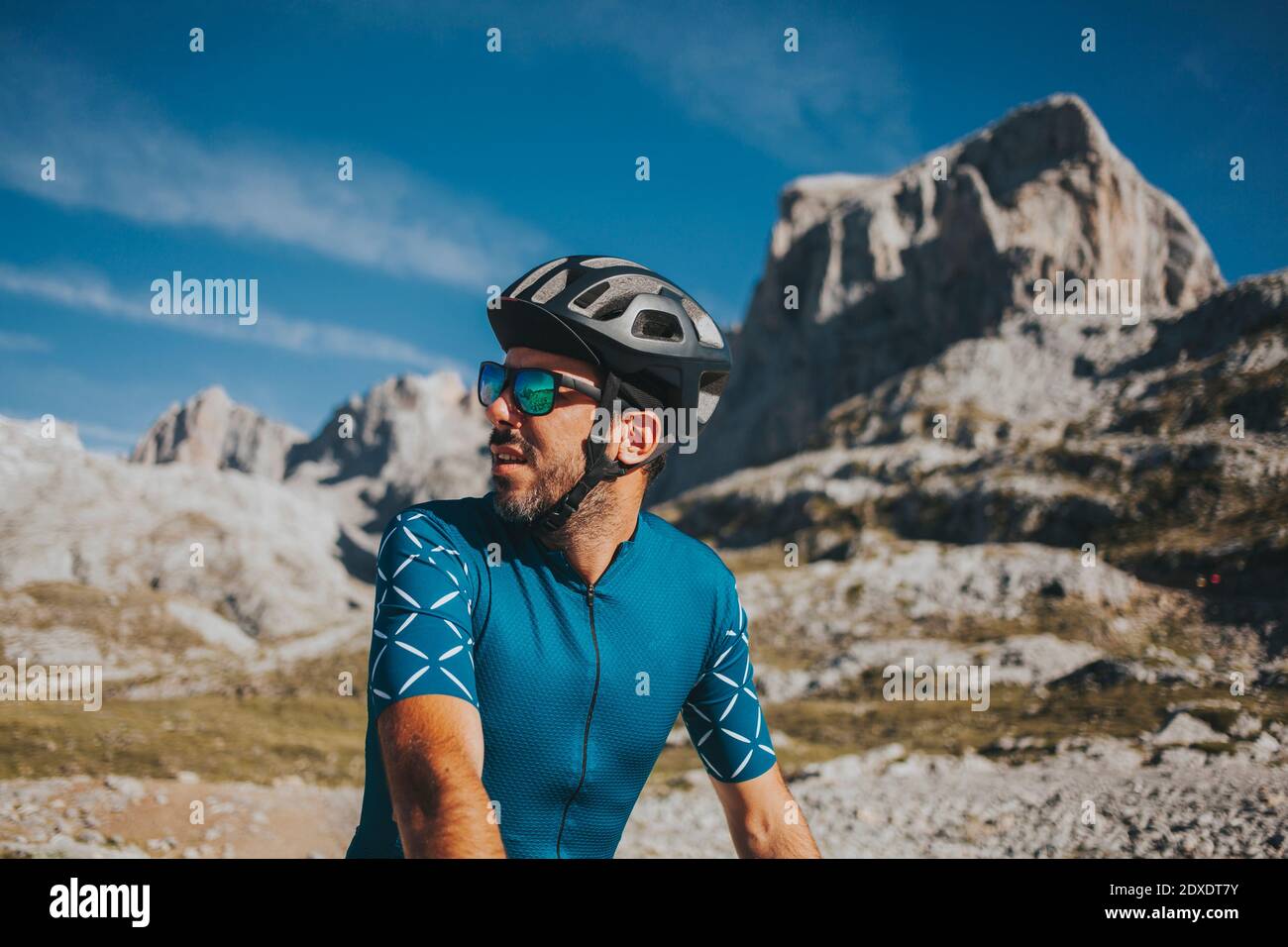 Ciclista maschile guardando via al famoso Parco Nazionale Picos de Europa in giornata di sole, Cantabria, Spagna Foto Stock