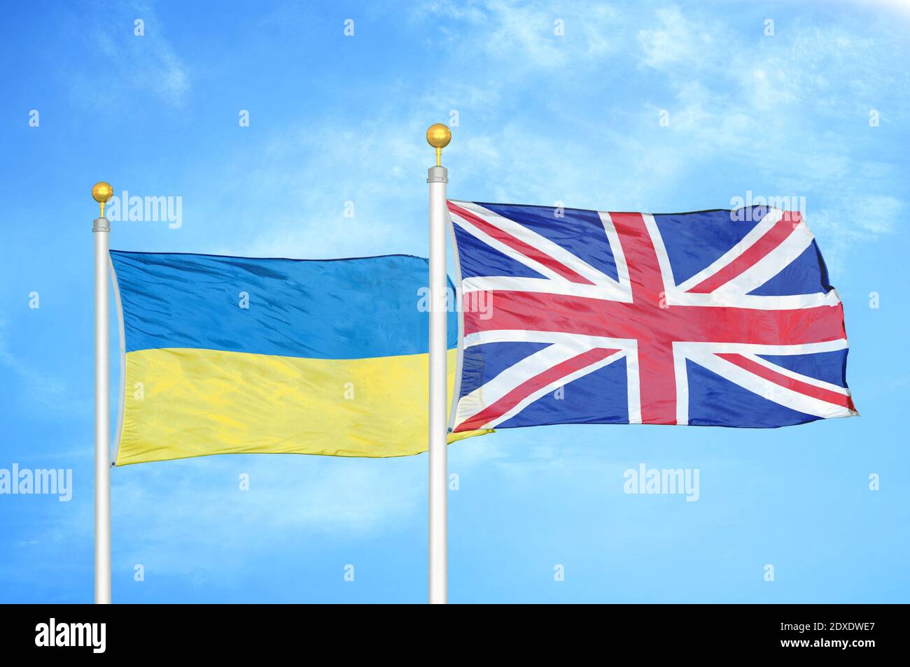 Ucraina e Regno Unito due bandiere su flagpoli e blu cielo Foto Stock