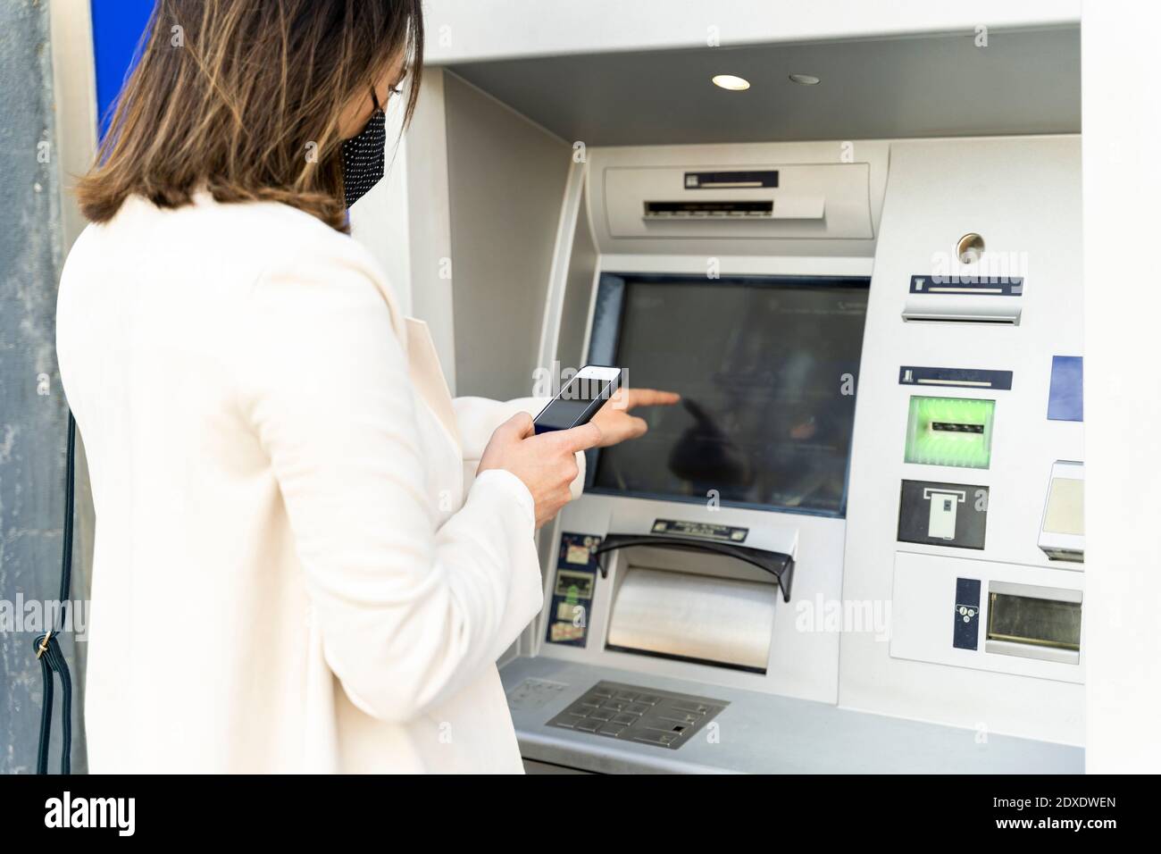 L'imprenditore femminile preleva denaro dagli ATM durante il COVID-19 Foto Stock