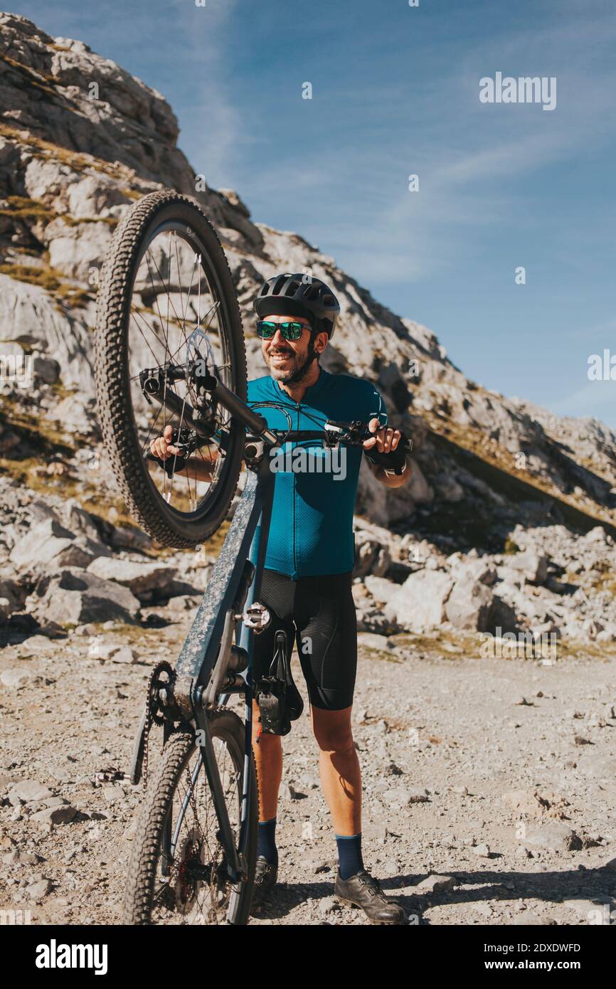 Giocoso ciclista maschile in mountain bike in giornata di sole, Parco Nazionale Picos de Europa, Cantabria, Spagna Foto Stock