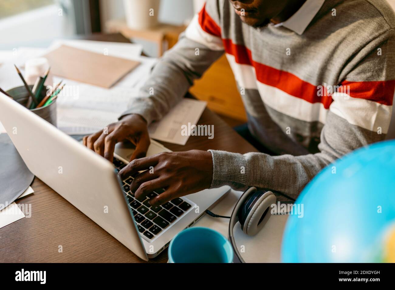 Freelance maschile che lavora su un computer portatile durante il lavoro da casa Foto Stock
