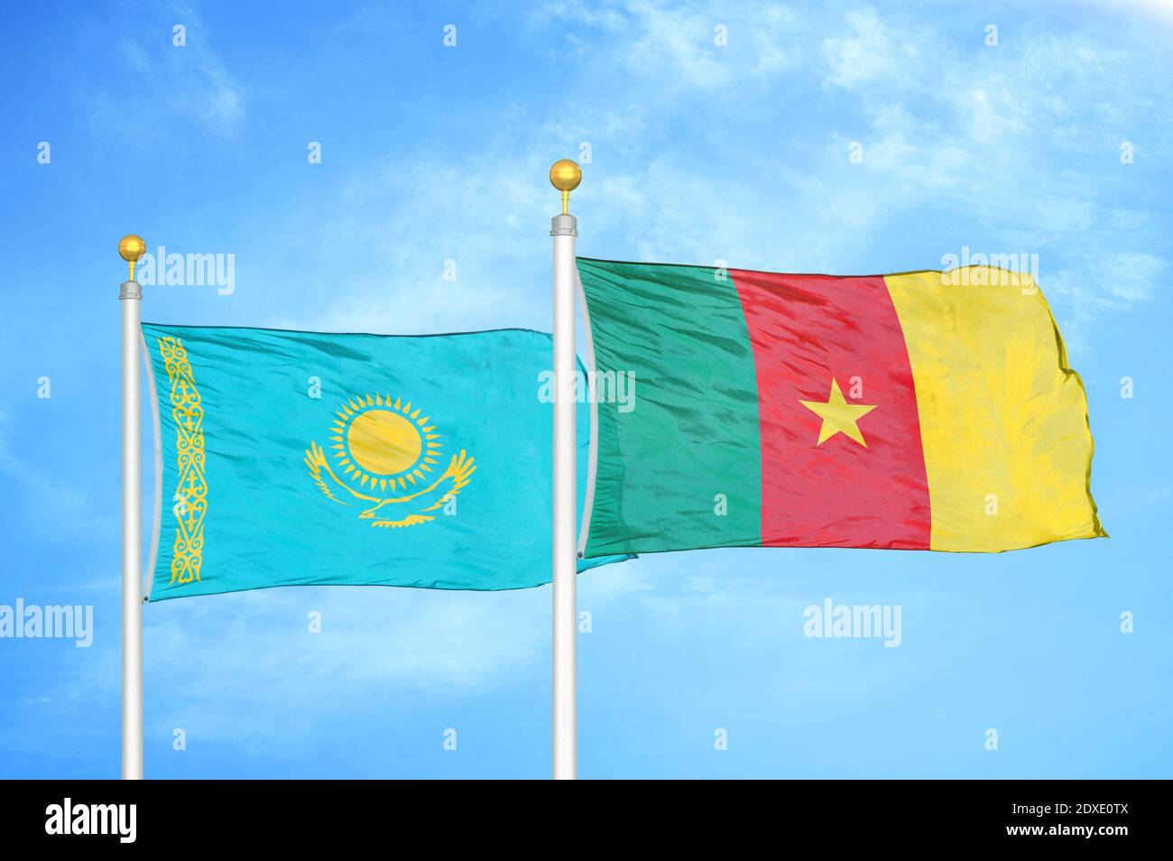 Kazakhstan e Camerun due bandiere su pali e cielo blu Foto Stock