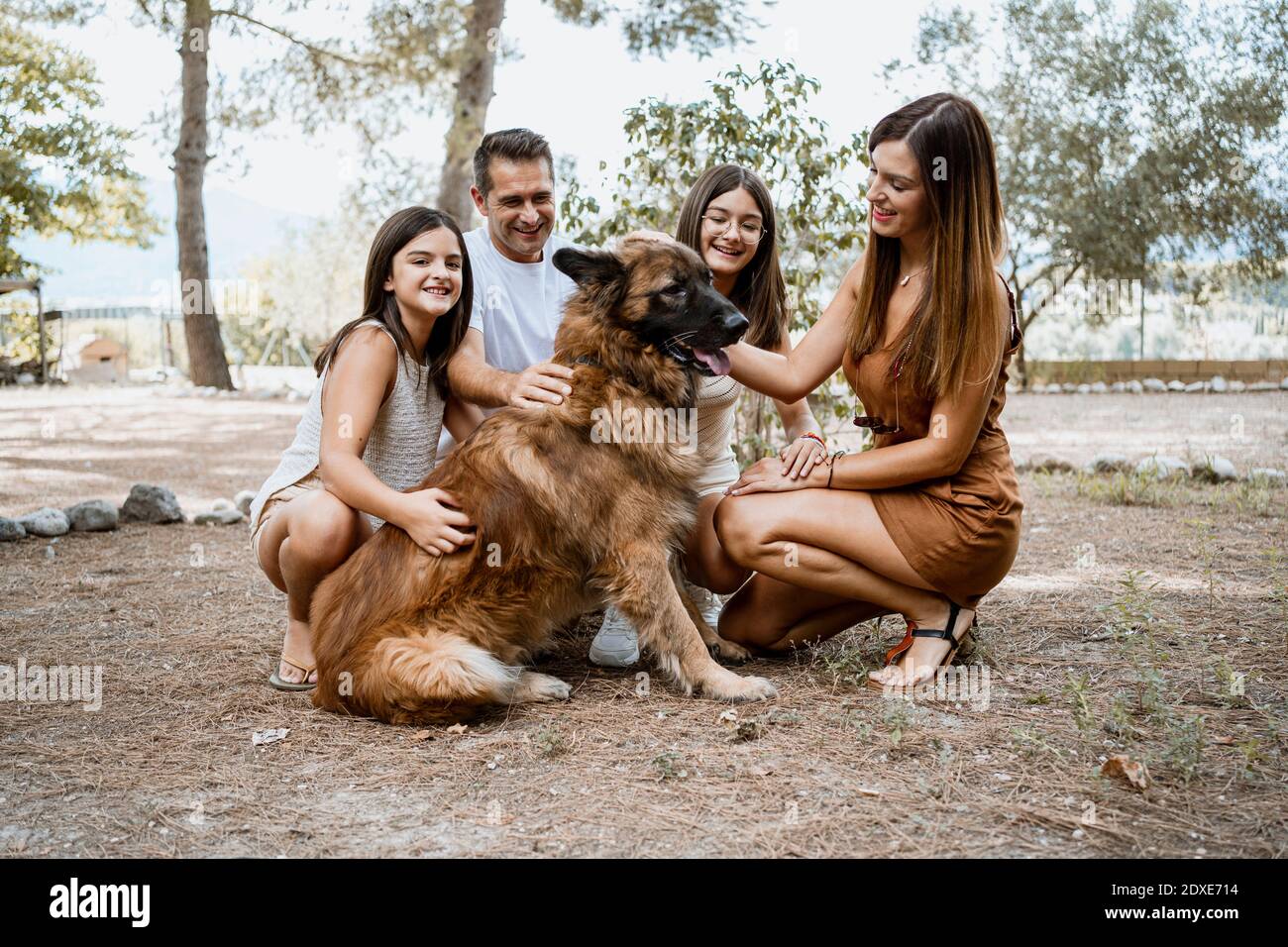 Sorridente famiglia con cane nel parco Foto Stock