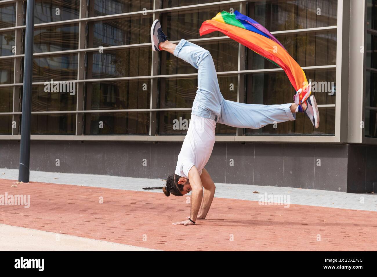 Uomo con sciarpa arcobaleno legato al supporto da allenamento alla caviglia città Foto Stock