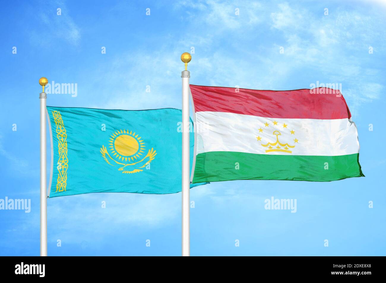 Kazakstan e Tagikistan due bandiere su pali e cielo blu Foto Stock