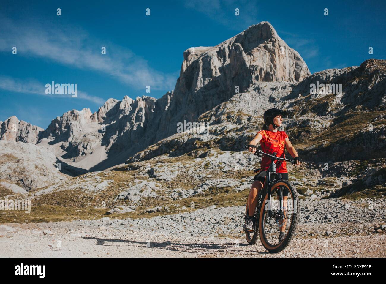 Ciclista femminile con bicicletta al Parco Nazionale di Picos de Europa in giornata di sole, Cantabria, Spagna Foto Stock