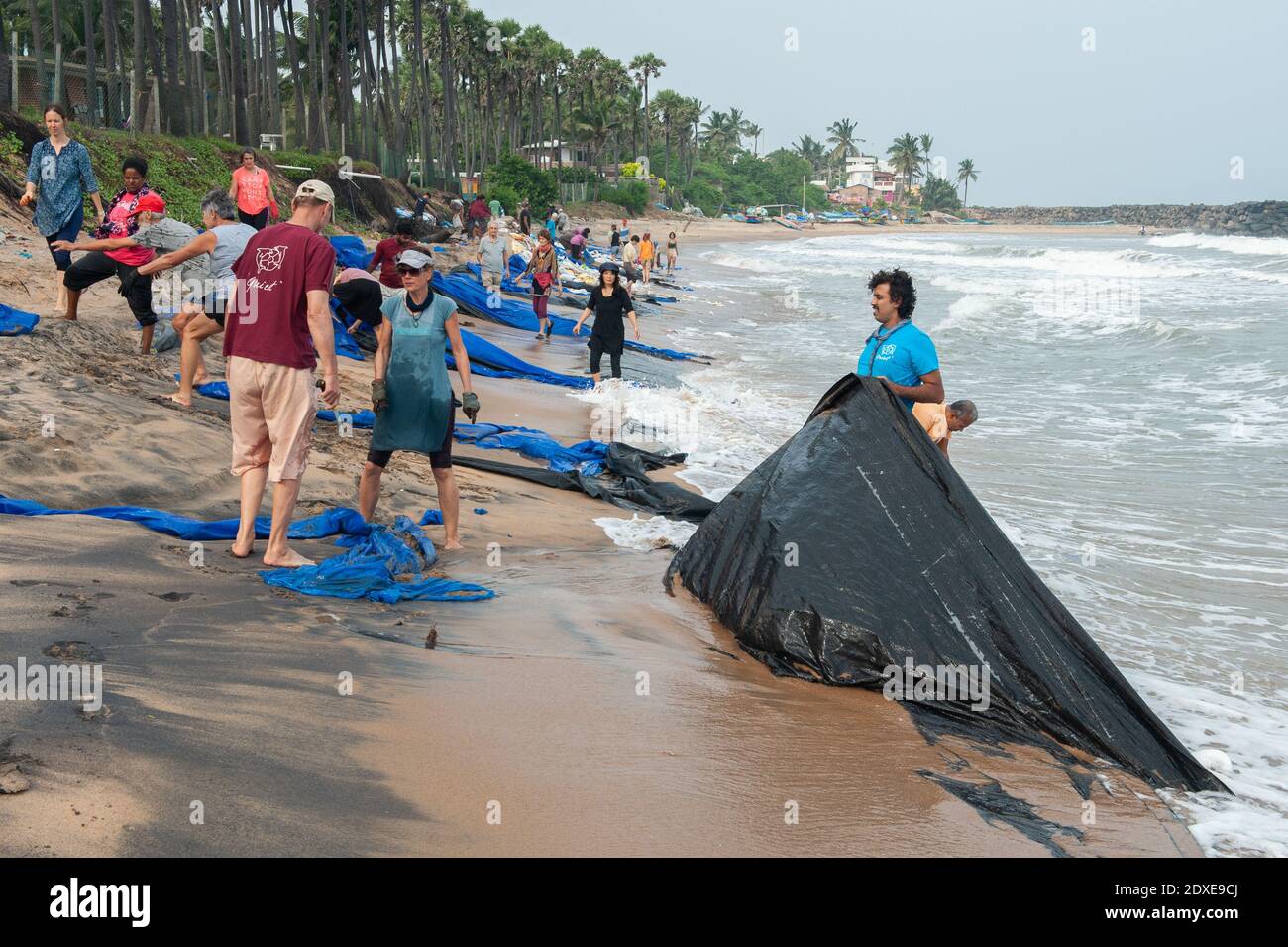 AUROVILLE, INDIA - 2020 dicembre: Pulire giorno per rimuovere la plastica a sinistra sulla spiaggia come protezione contro l'erosione del mare Foto Stock