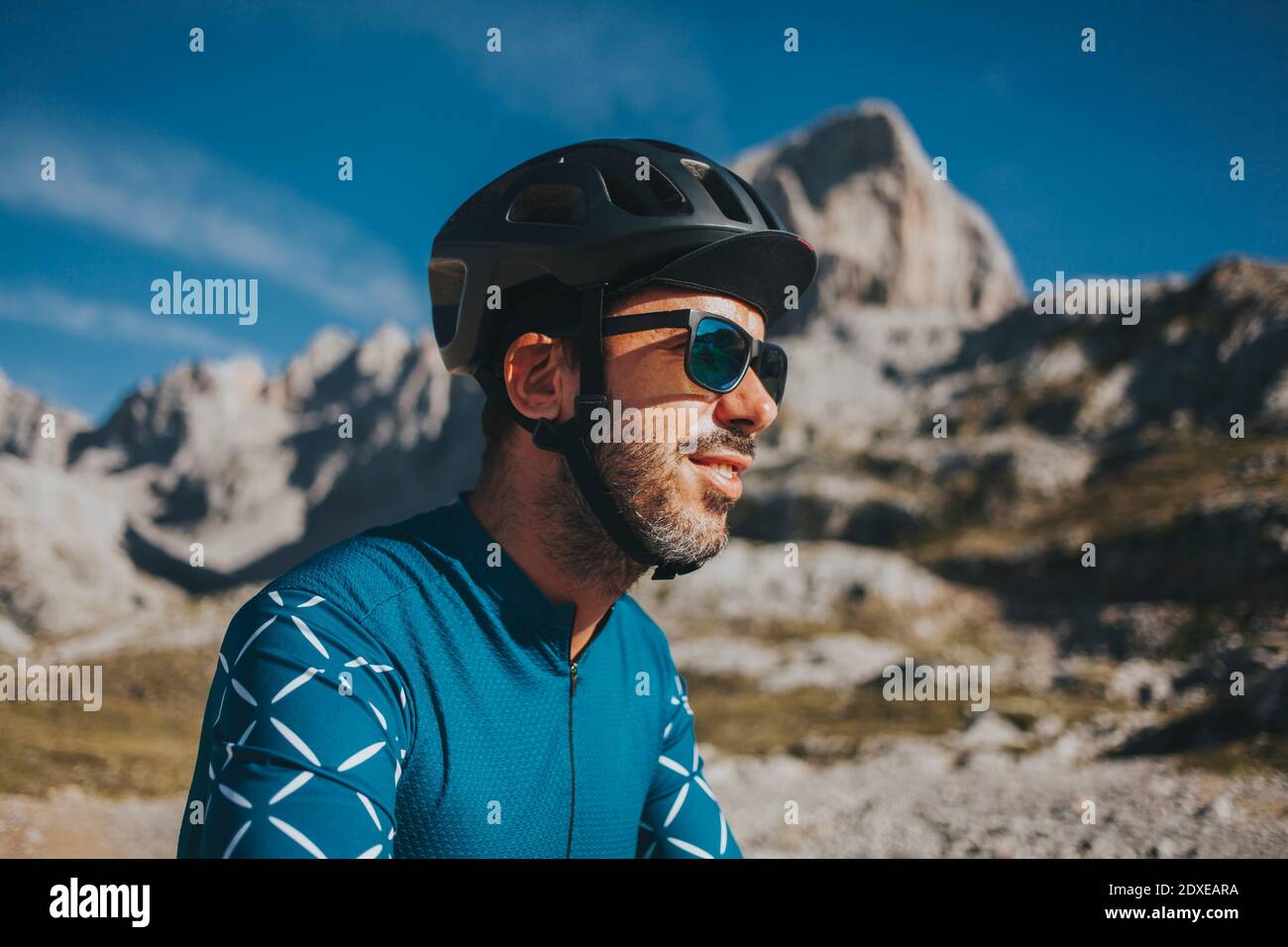 Ciclista che indossa occhiali da sole e casco da ciclismo al Parco Nazionale di Picos de Europa nella giornata di sole, Cantabria, Spagna Foto Stock