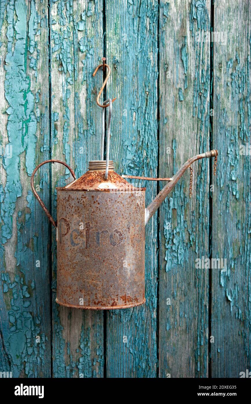 L'olio arrugginito può appendere sul vecchio muro di legno Foto Stock