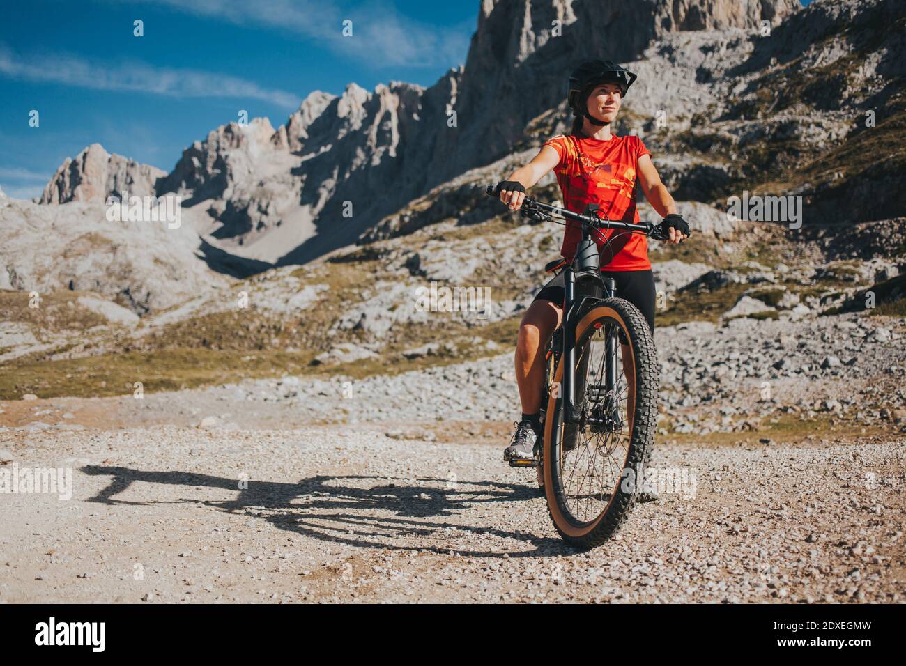 Donna con mountain bike al Parco Nazionale di Picos de Europa in giornata di sole, Cantabria, Spagna Foto Stock