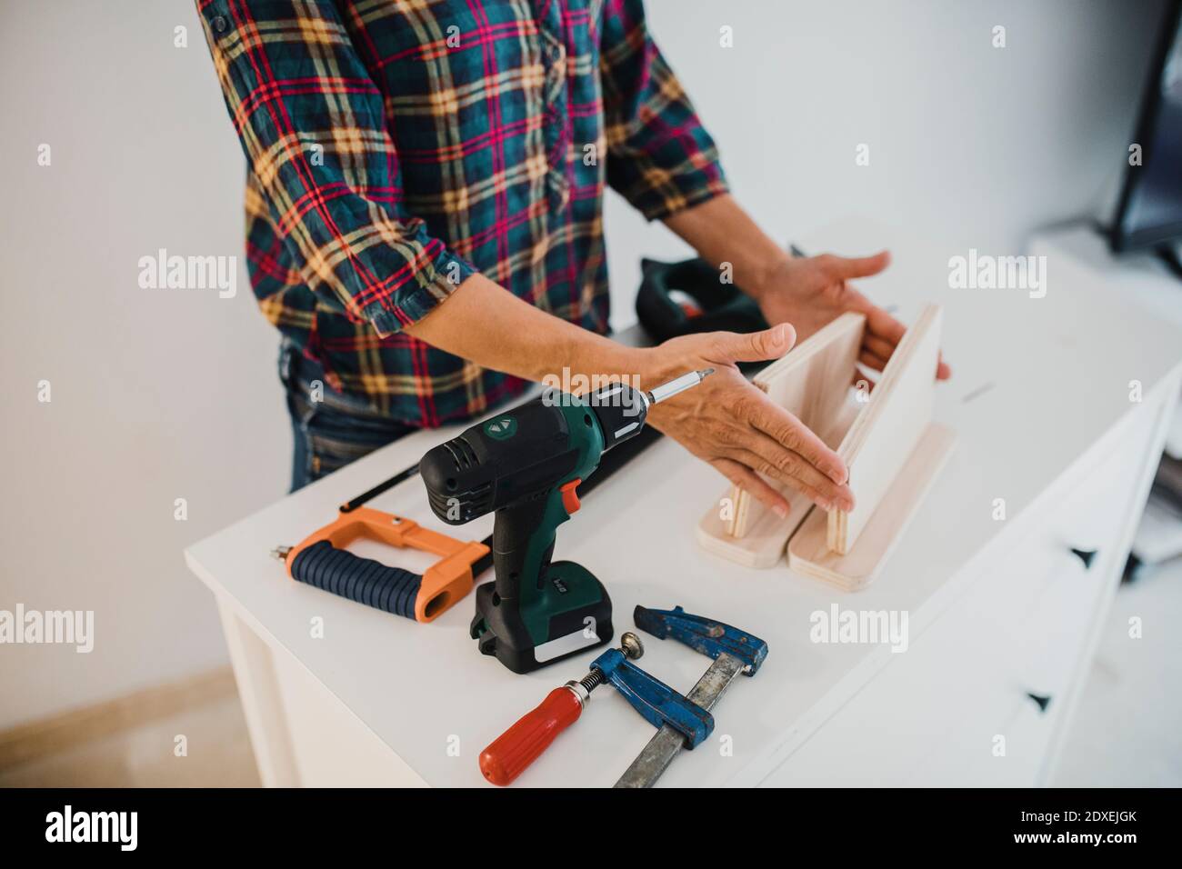 Donna che lavora con legno e utensili a casa Foto Stock