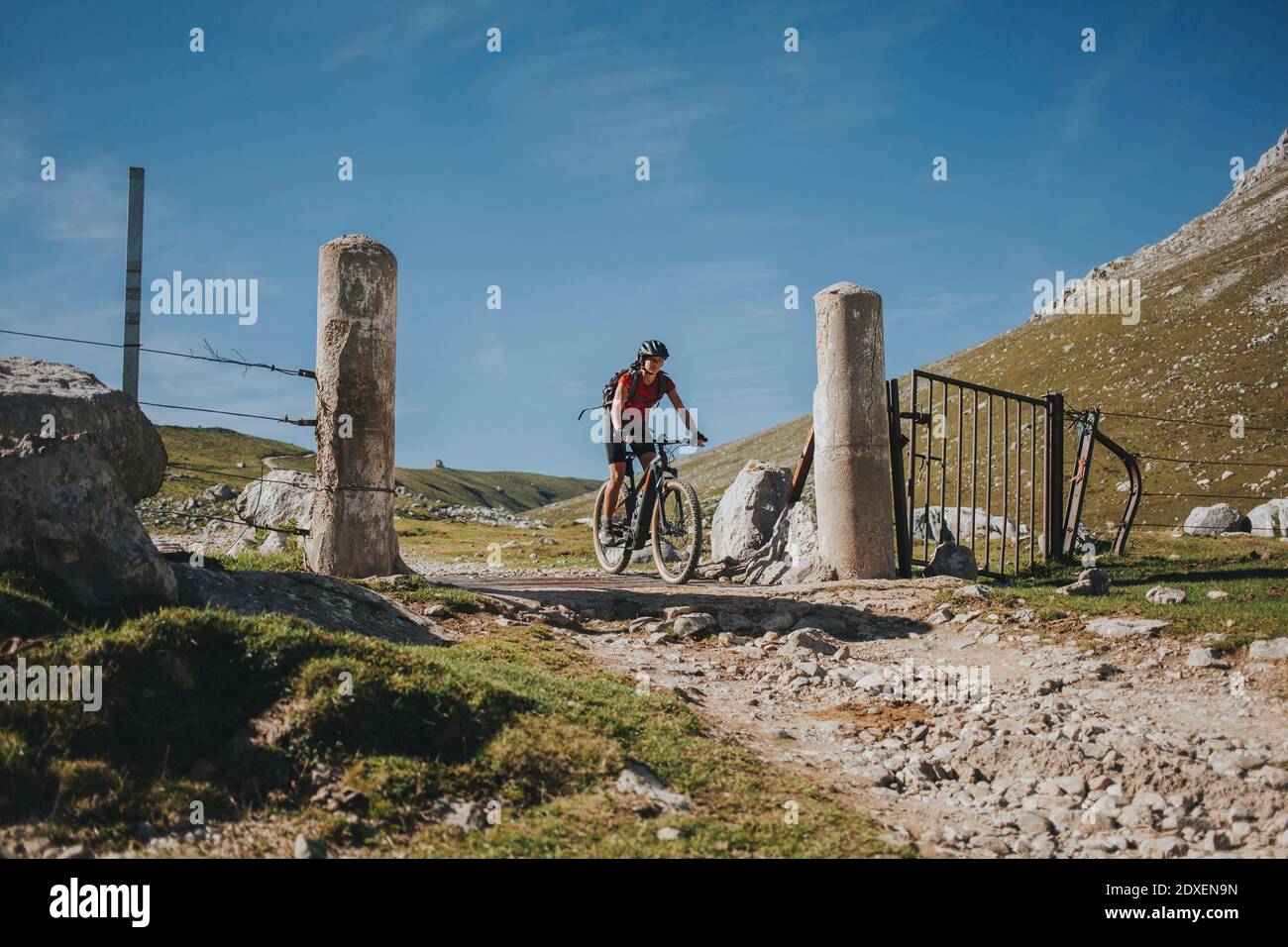 La ciclista femminile che attraversa la Canatabria e le Asturie confina con il Parco Nazionale Picos de Europa, Cantabria, Spagna Foto Stock