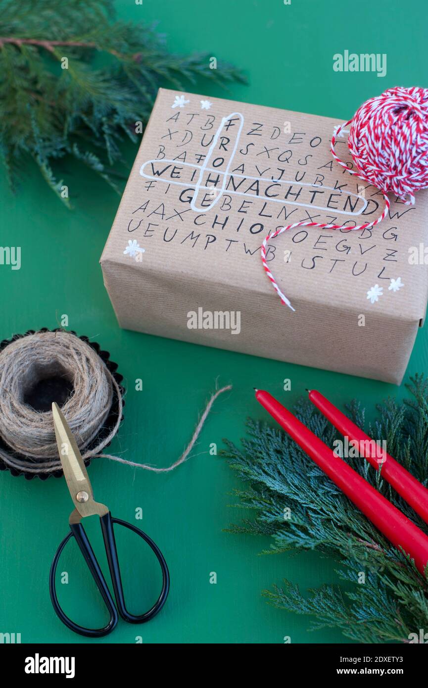 Forbici, stringa e puzzle di ricerca di parole su regalo di Natale avvolto Foto Stock