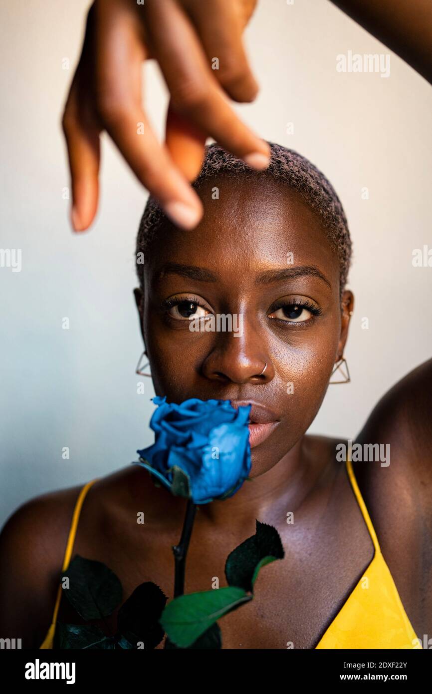 Hipster femminile sicuro con rosa blu a casa Foto Stock