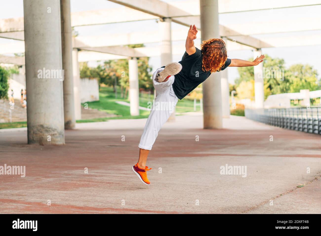 Il salto di pratica di Acrobat mentre esercitandosi al parco Foto Stock