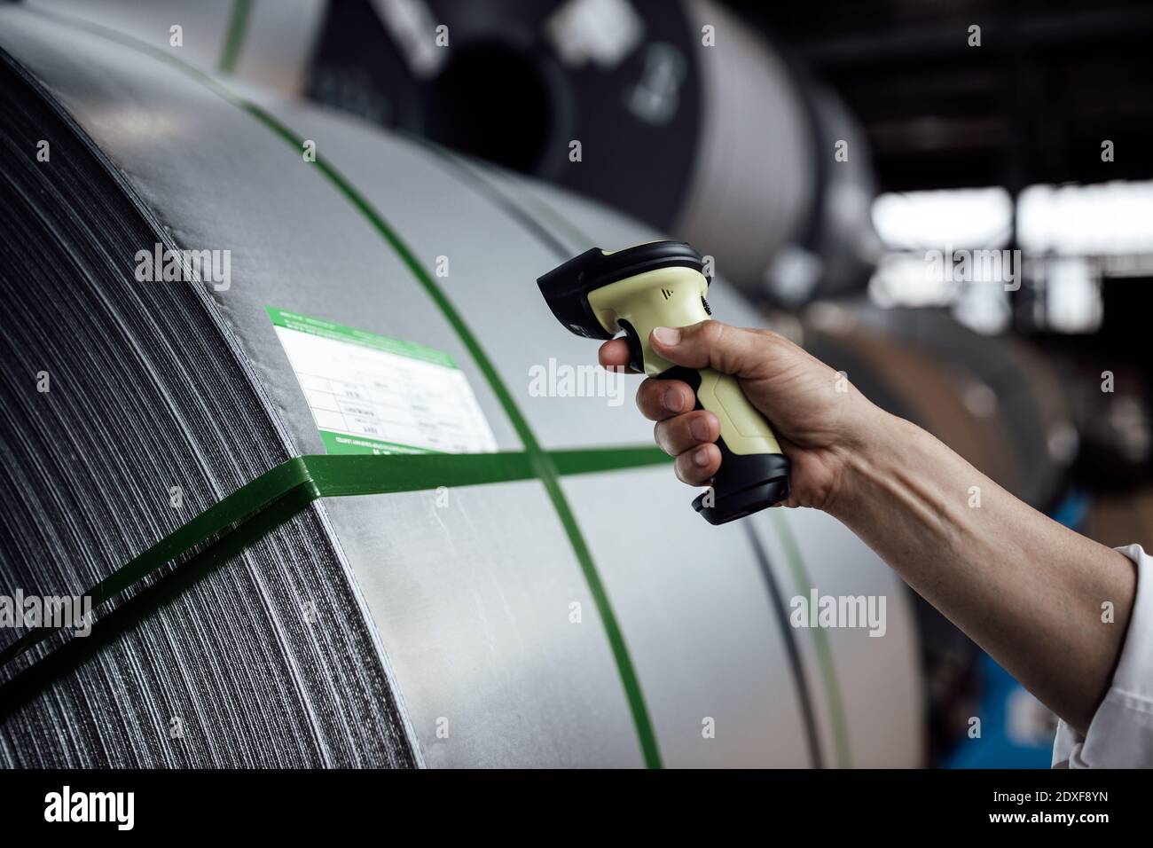Codice a barre di scansione manuale su rotoli di acciaio nell'industria Foto Stock