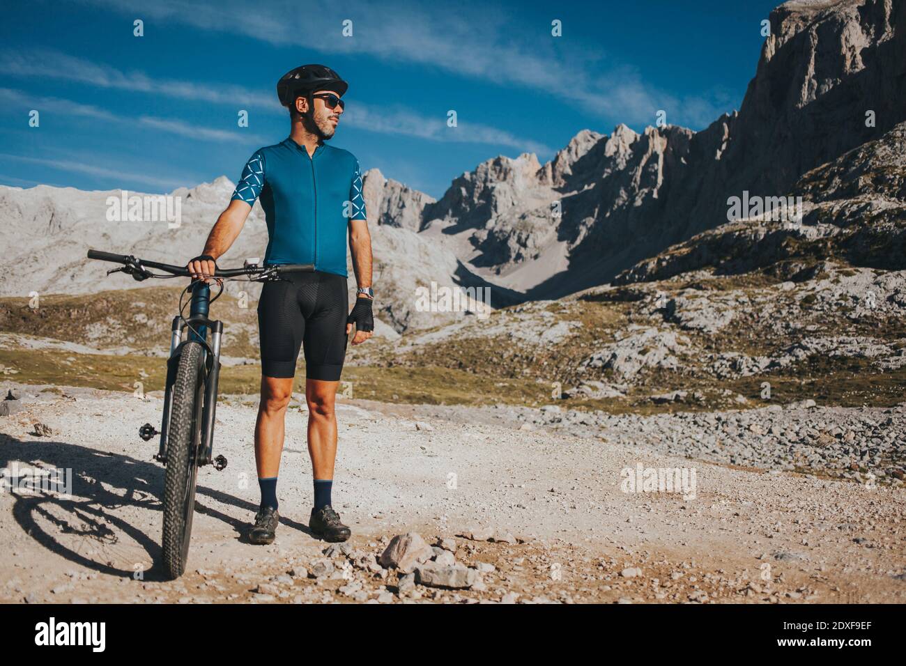 Ciclista maschile guardando via mentre si sta in bicicletta al Parco Nazionale di Picos de Europa, Cantabria, Spagna Foto Stock
