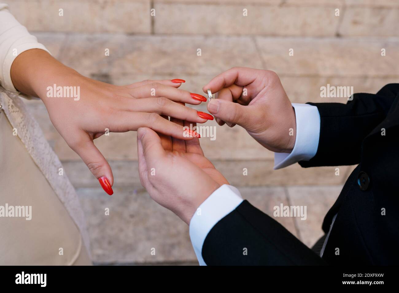 Anello di posizionamento dello sposo sulla sposa durante il giorno del matrimonio Foto Stock