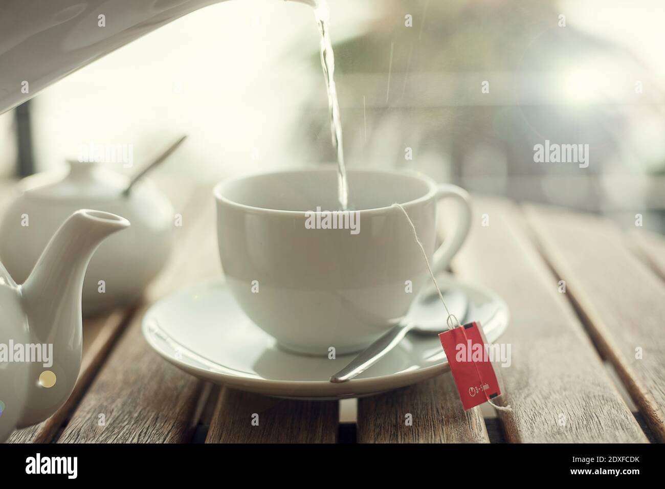 L'acqua viene versata in una tazza da tè bianca Foto Stock