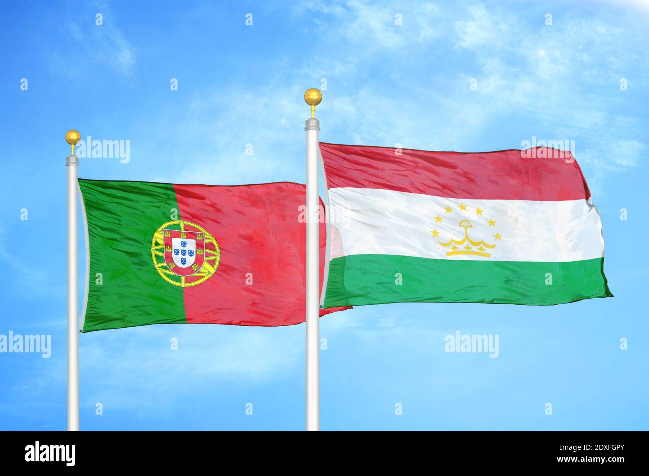 Portogallo e Tagikistan due bandiere su pali e cielo blu Foto Stock