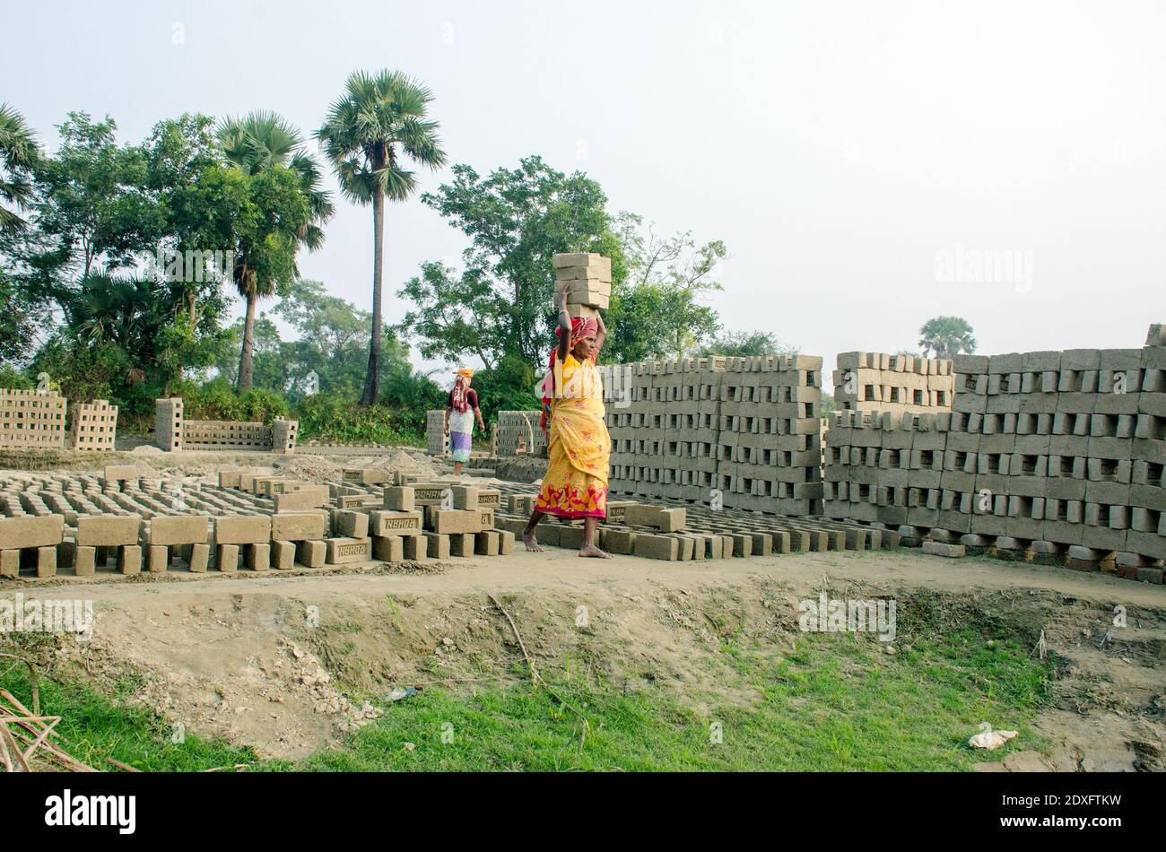 Immagine di un forno di mattoni nel remoto distretto di Hooghly. Lavoratori adulti lavorano duro per disporre i mattoni crudi nel forno per essere cotti. Foto Stock