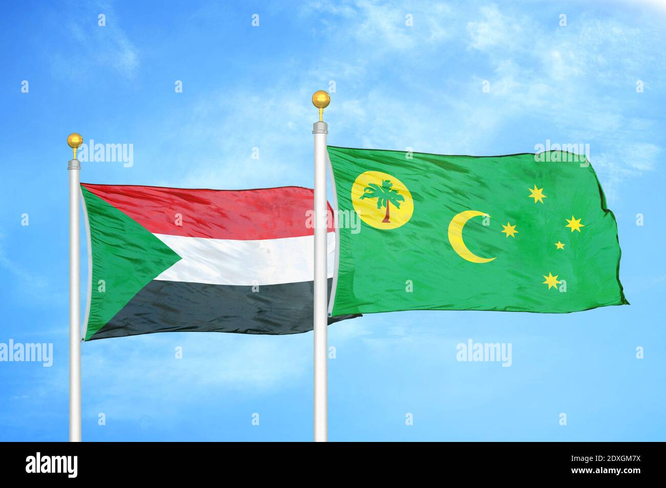 Sudan e Cocos Keeling Isole due bandiere su flagpoli e. cielo blu Foto Stock